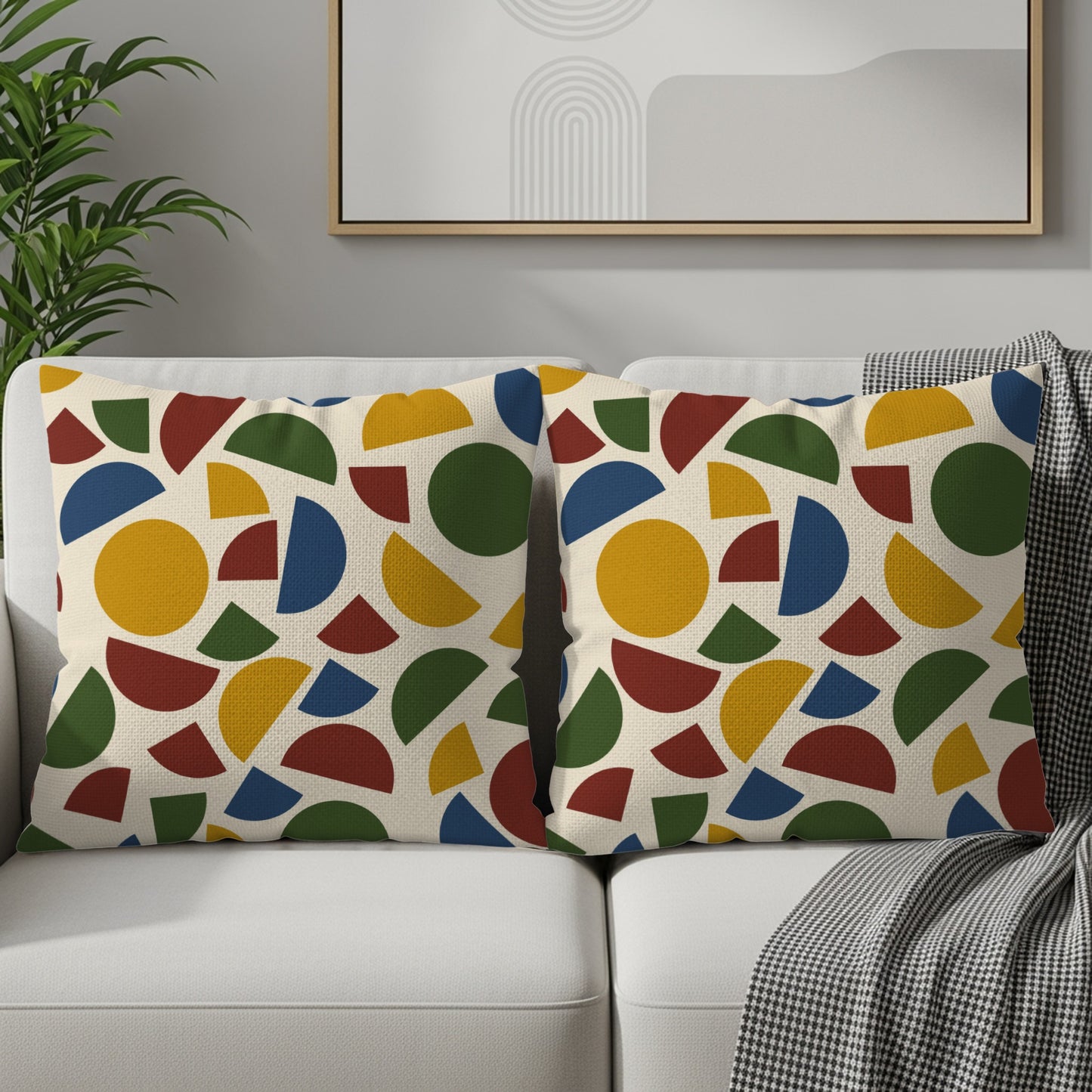 Two beige throw pillows with a repeating geometric pattern of circles and semi-circles.