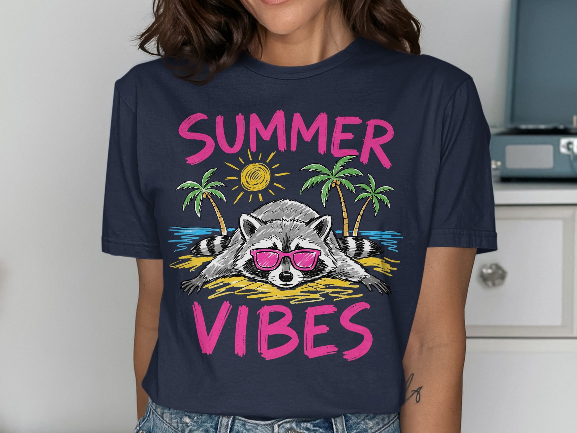 T-shirt graphic of a raccoon wearing sunglasses on a beach with palm trees and text.