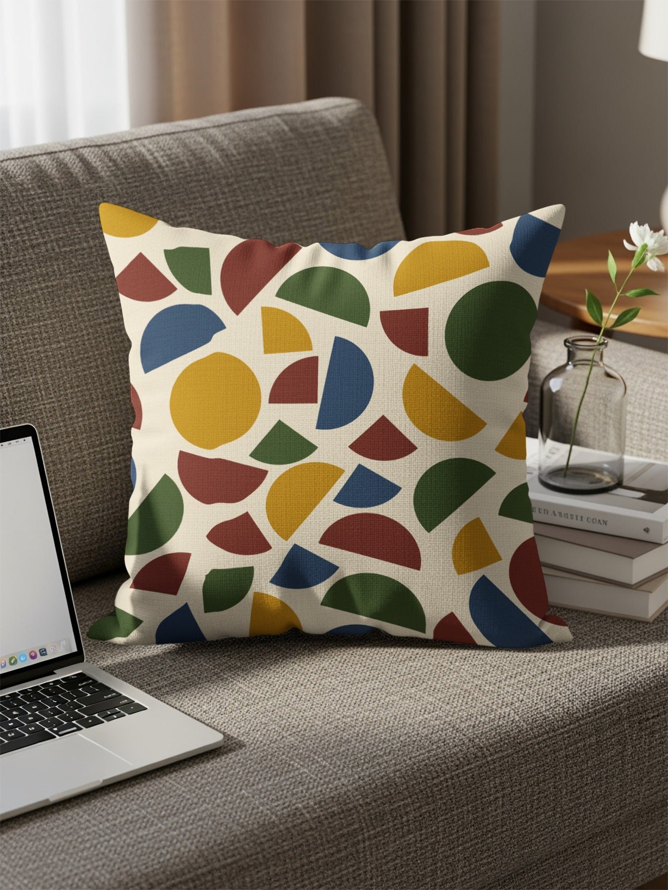 Throw pillow with a geometric abstract pattern of beige, yellow, blue, red, and green shapes.