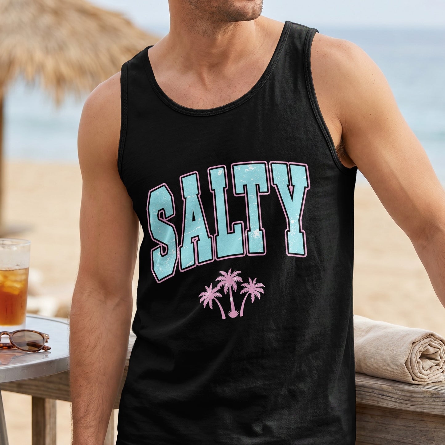 Black tank top with "SALTY" text and palm trees, worn by a man.