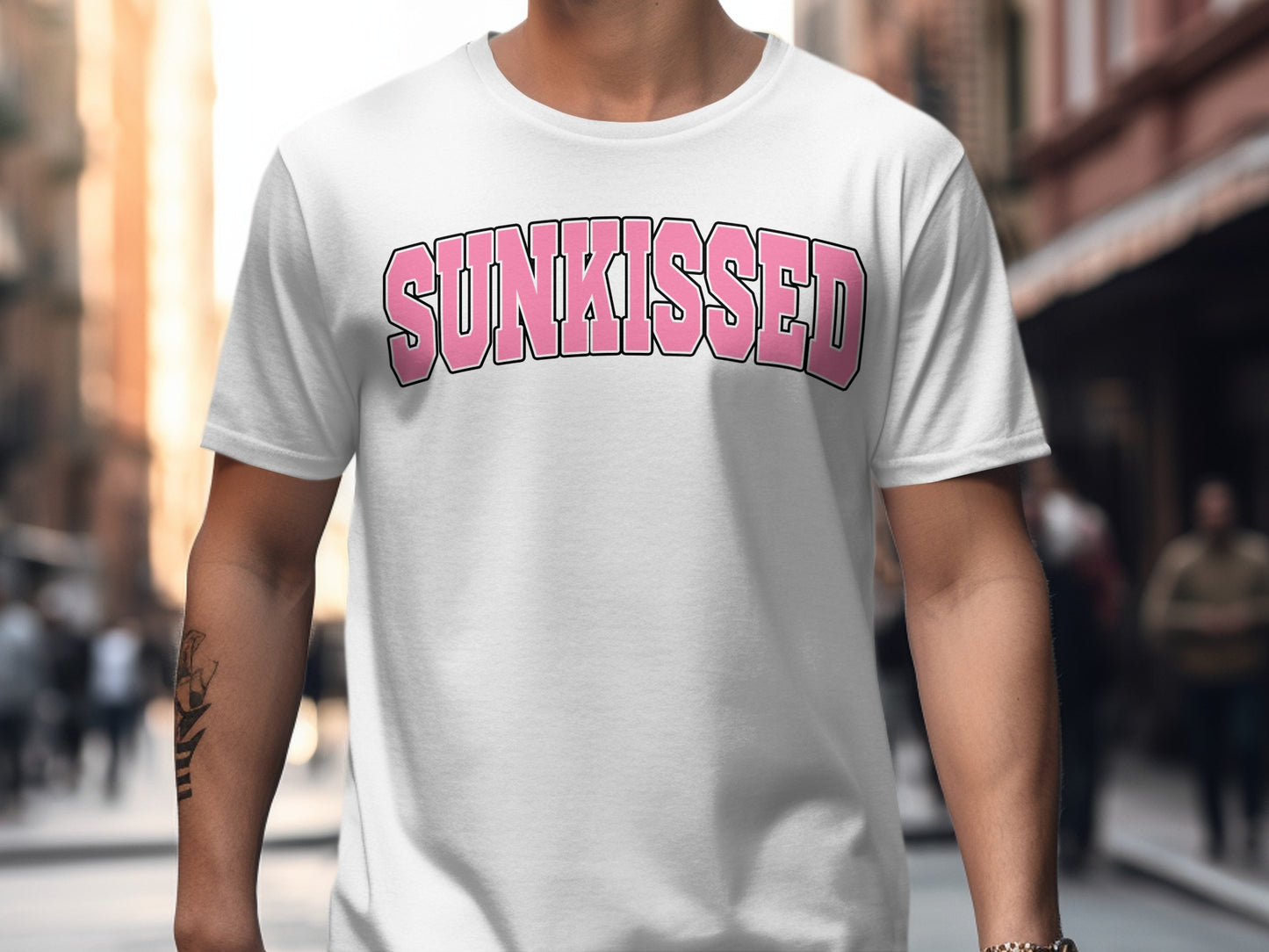 White t-shirt with "SUNKISSED" printed in pink, bold, arched text.