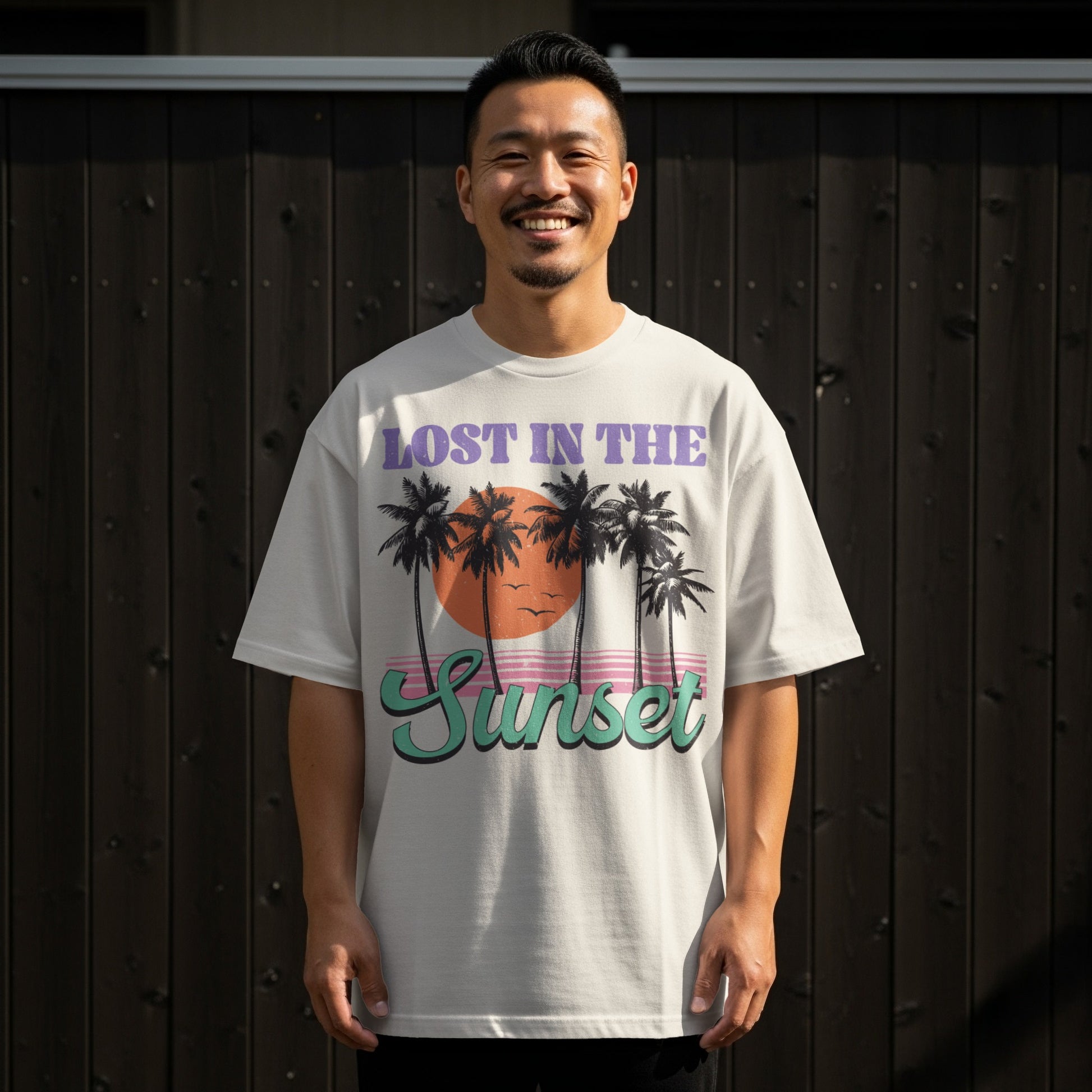 White t-shirt with "Lost in the Sunset" text and palm trees graphic.
