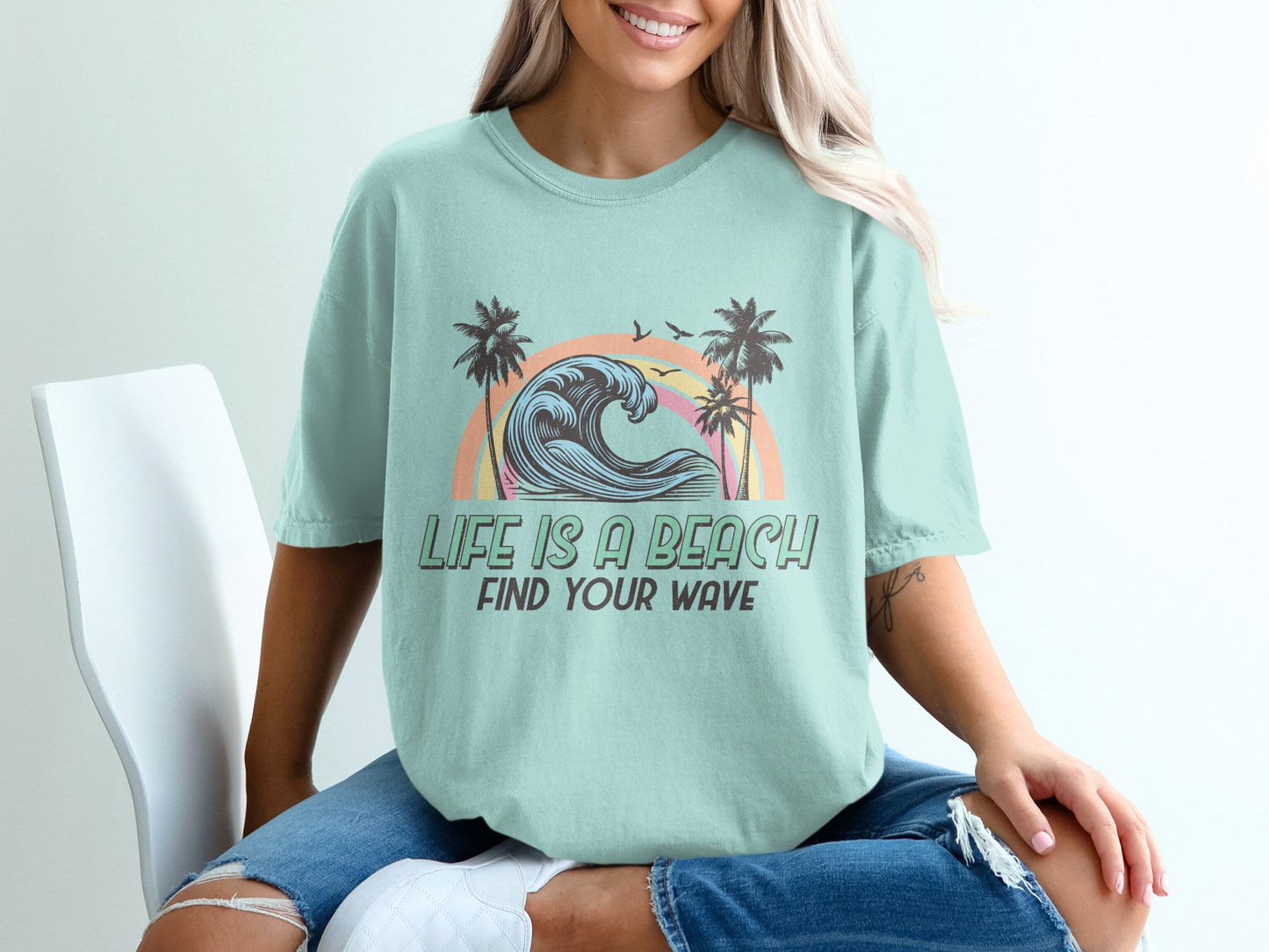 Mint t-shirt with sunset, palm trees, and "Life is a Beach, Find Your Wave" text.