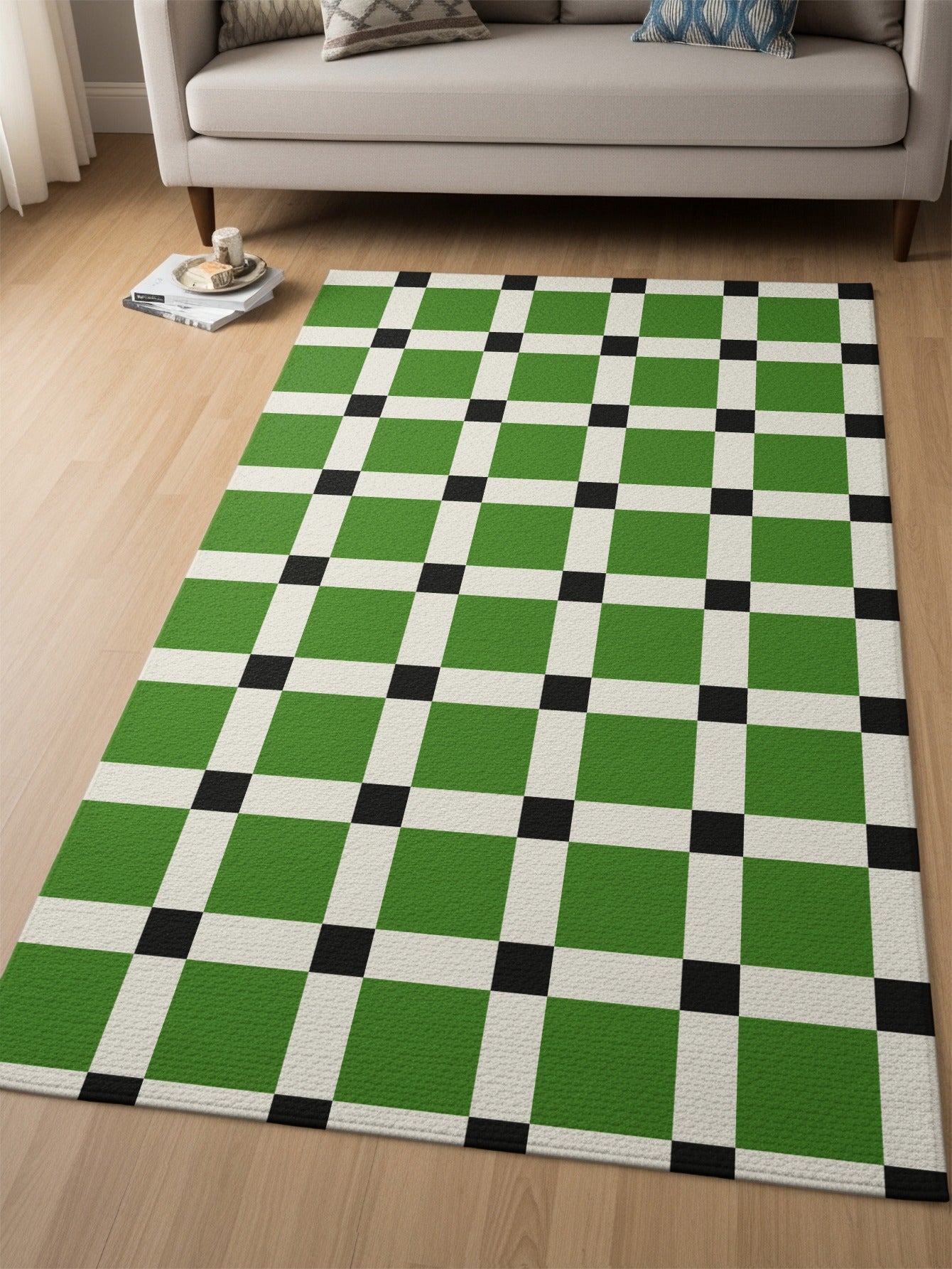 Green, black, and white checkerboard rug on a hardwood floor next to a sofa.