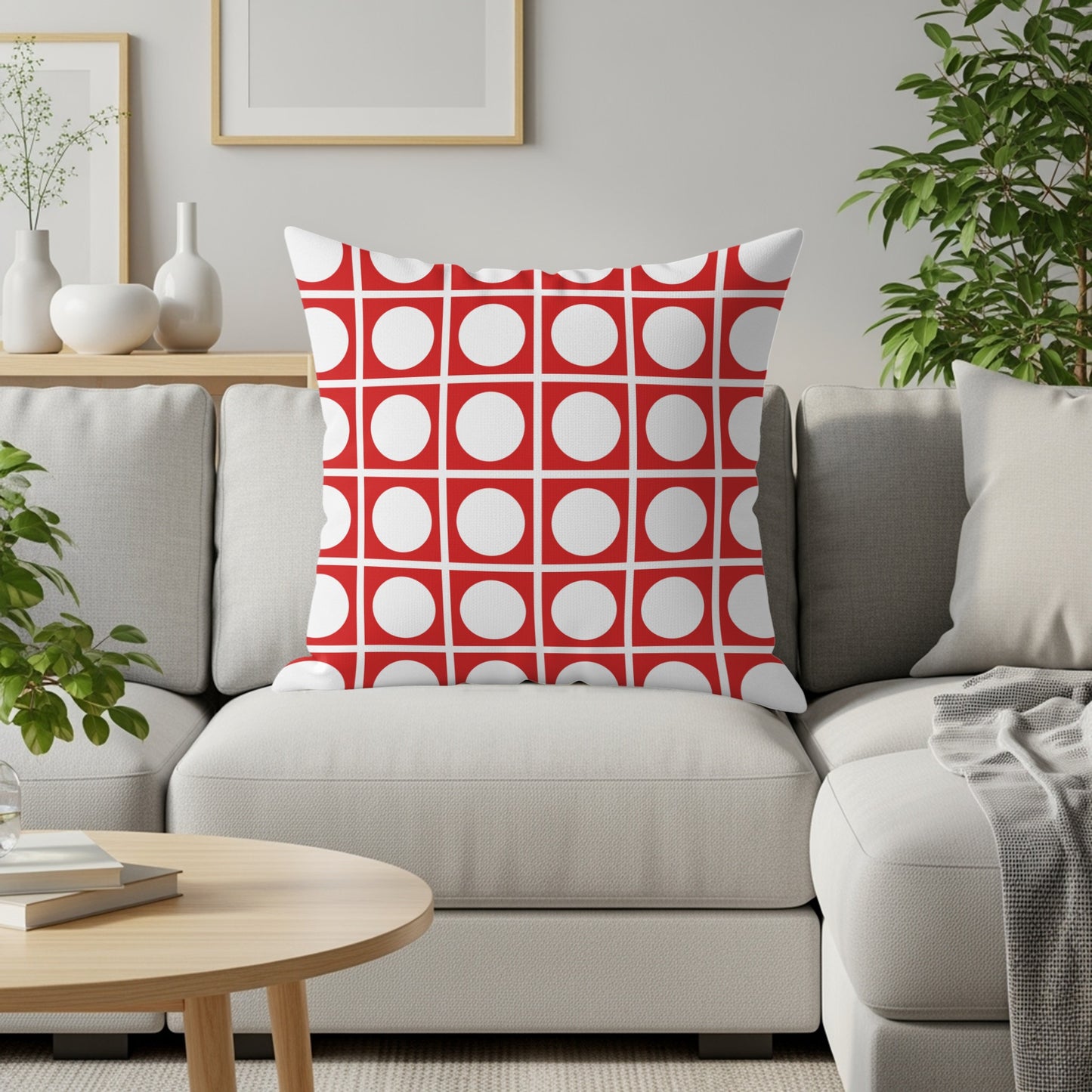Red and white square pattern throw pillow on a light gray couch.