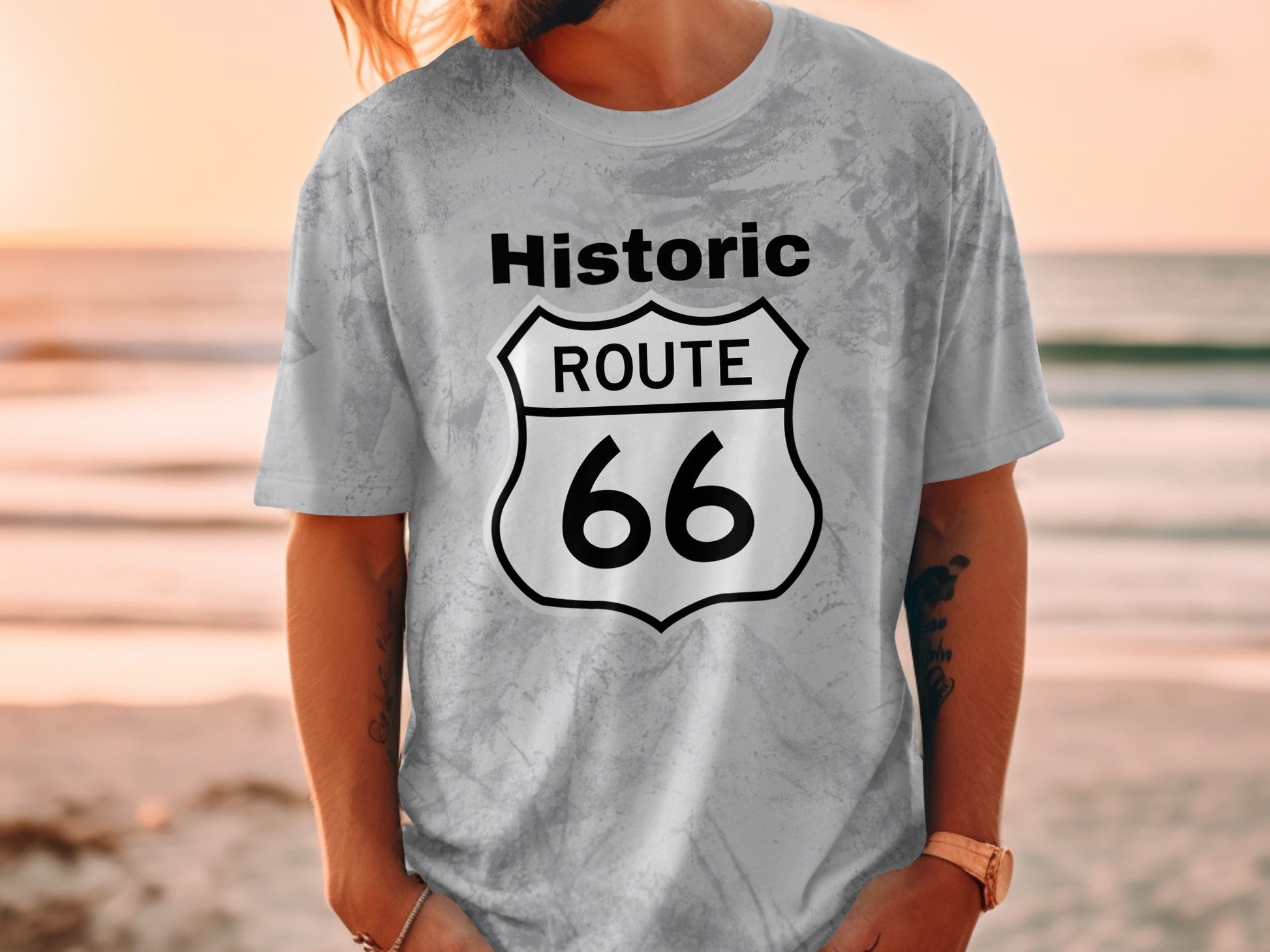 Gray marbled t-shirt with Route 66 shield logo, beach background.