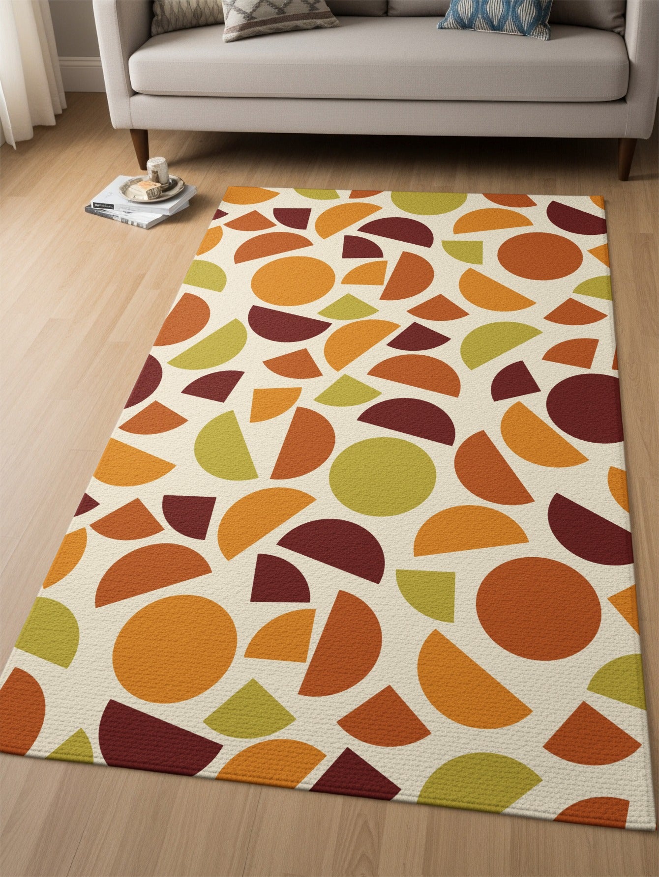 Abstract geometric shapes in cream, orange, maroon, and green scattered across a rug.