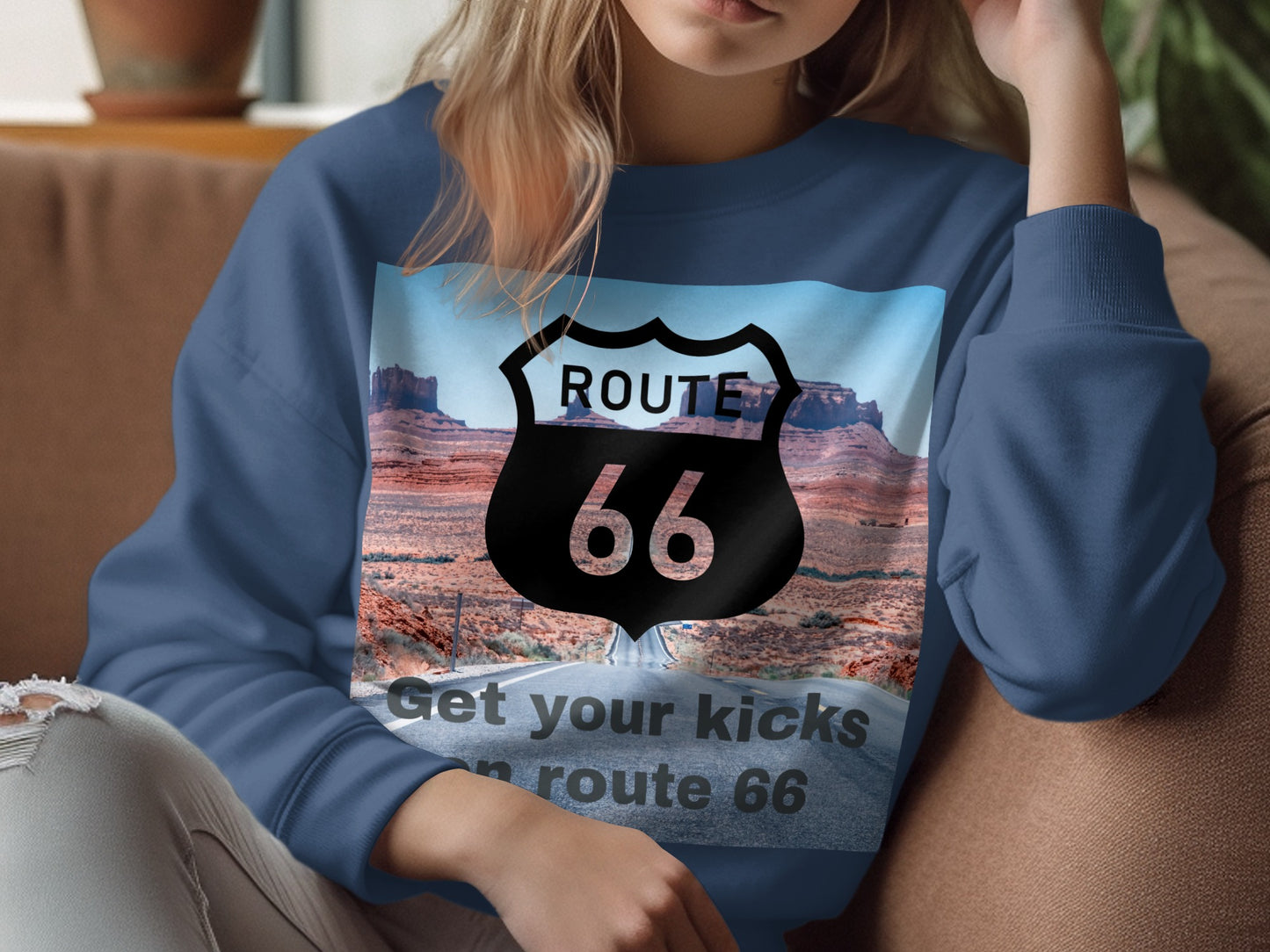 Woman wearing a blue sweatshirt with a Route 66 logo and desert landscape.