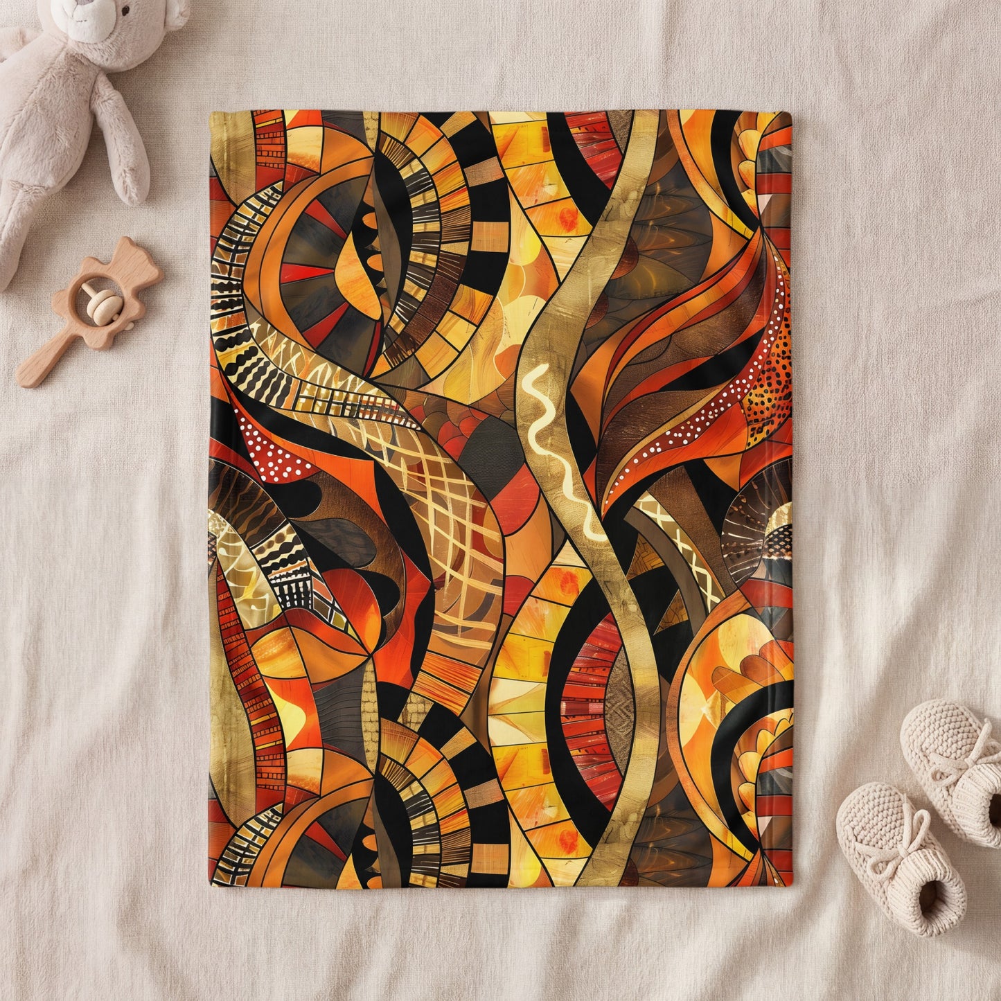 Blanket with abstract orange, yellow, and brown animalistic print and baby items.