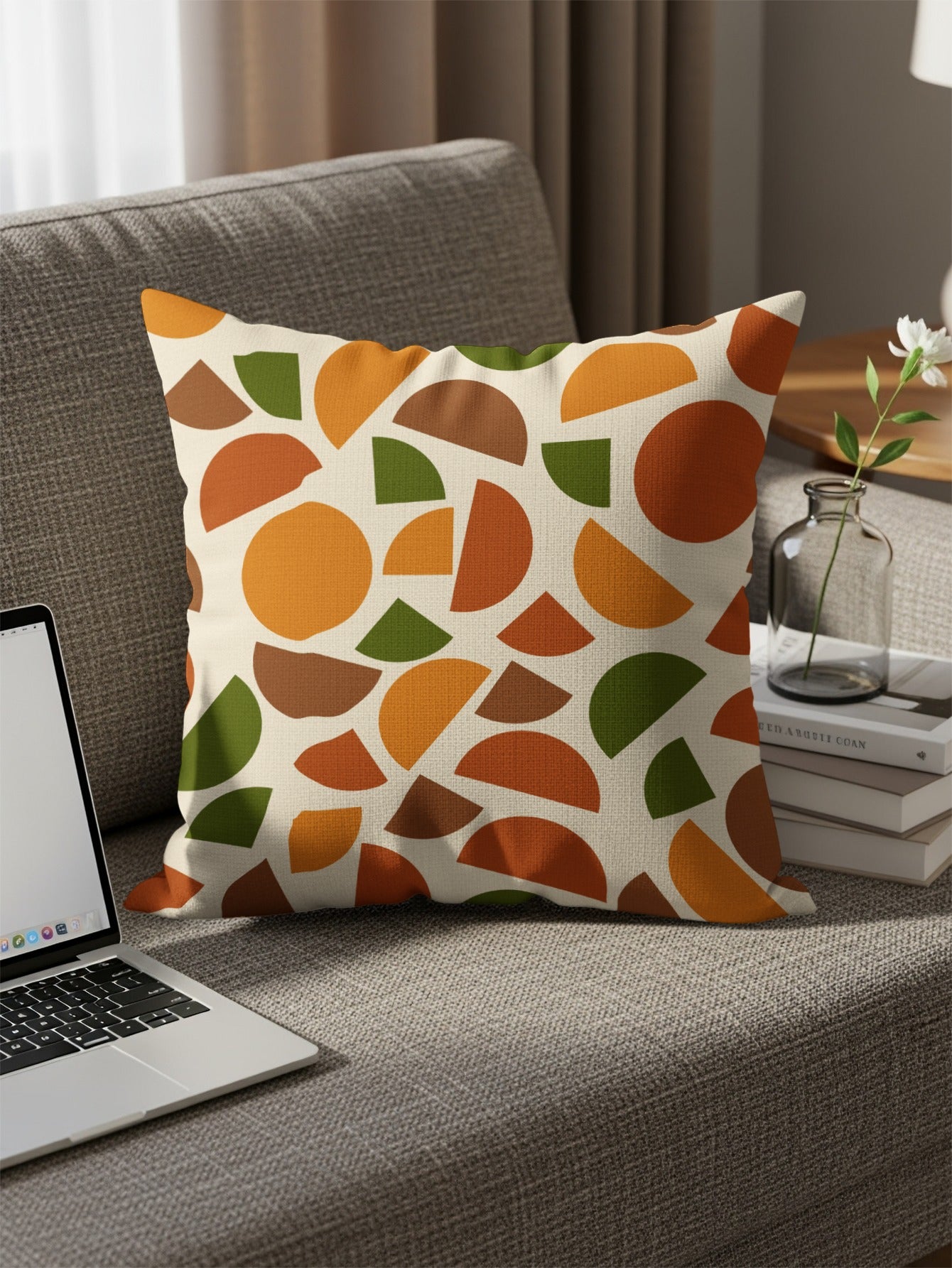 Throw pillow with abstract terracotta, orange, brown, and green geometric pattern.