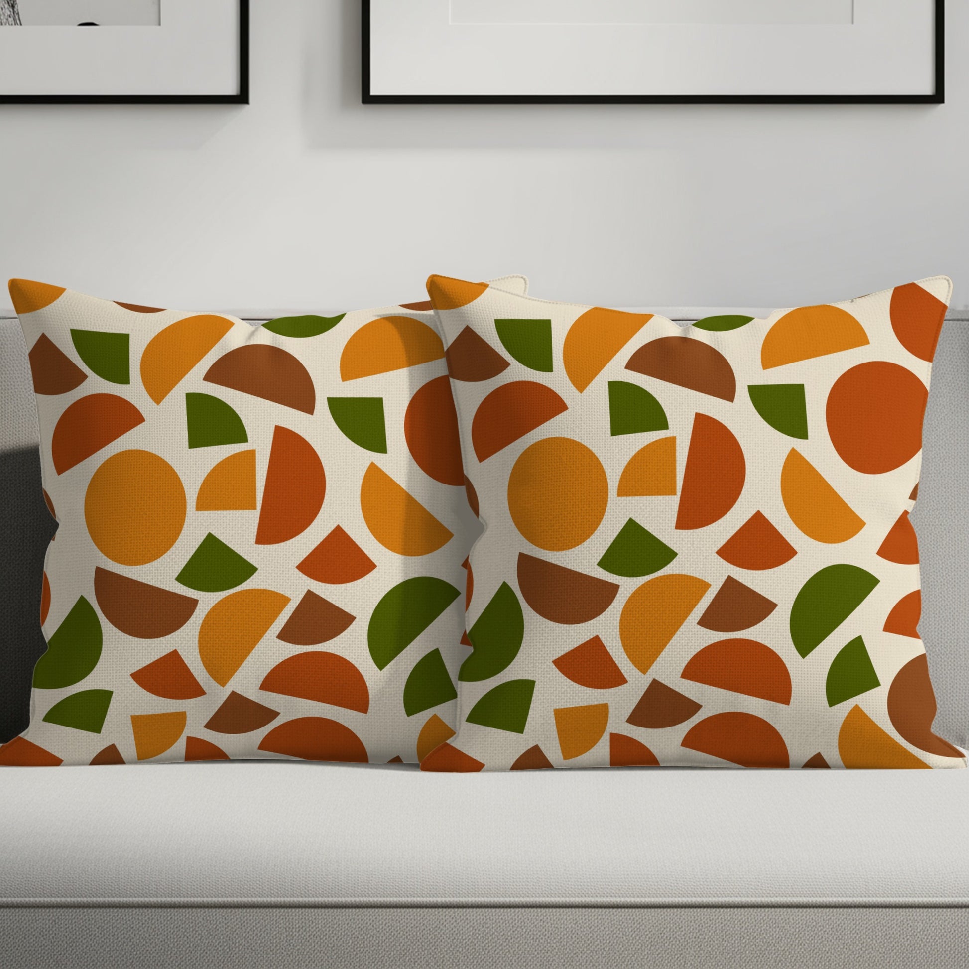 Two decorative pillows with a geometric pattern of circles and semi-circles in rust, green, and orange.