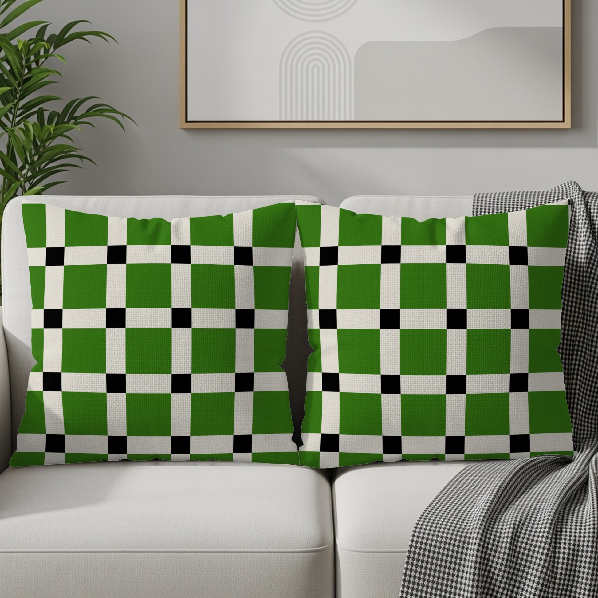Two lumbar pillows with a green, white, and black checkerboard pattern on a sofa.