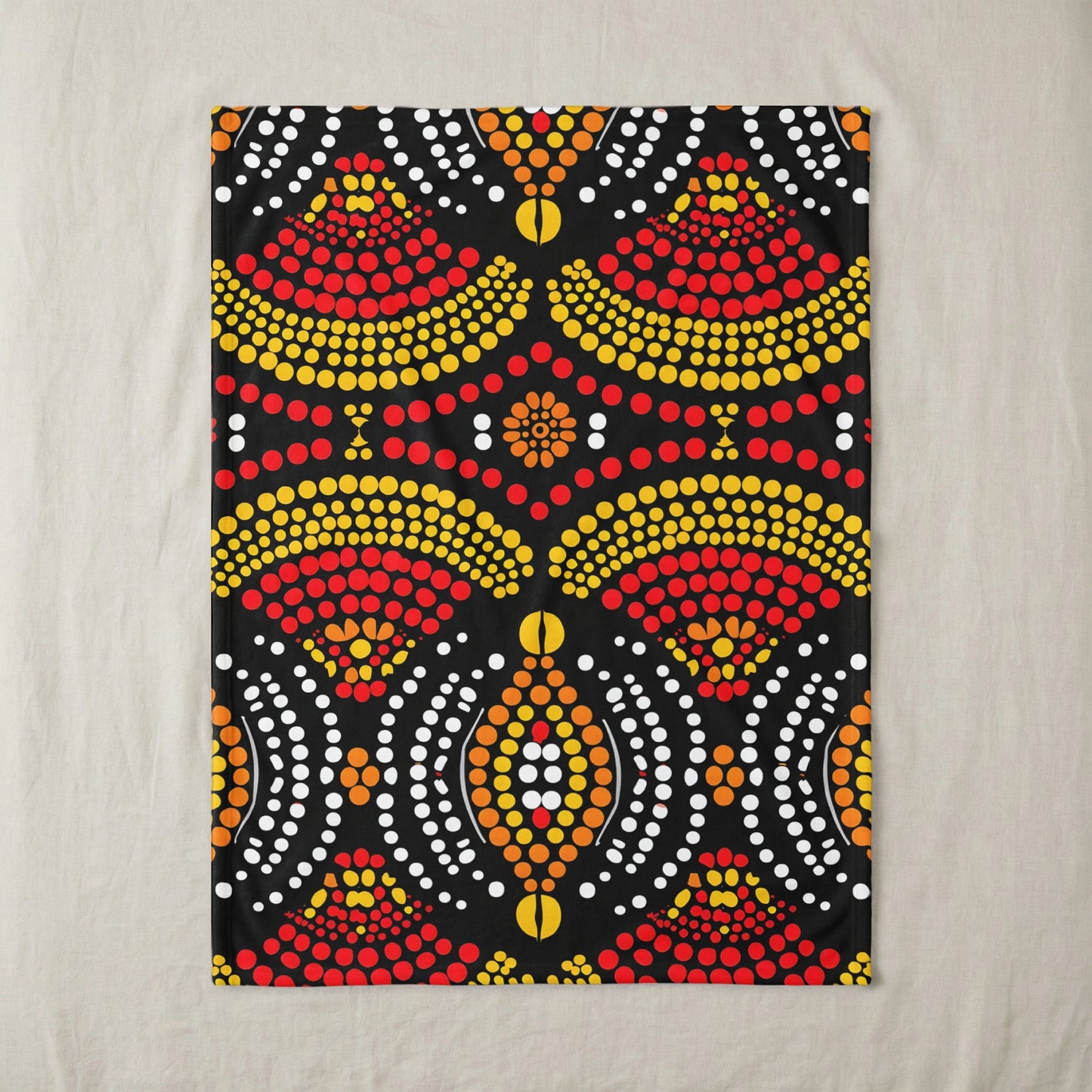 Black textile with a symmetrical dot pattern in red, yellow, orange, and white.