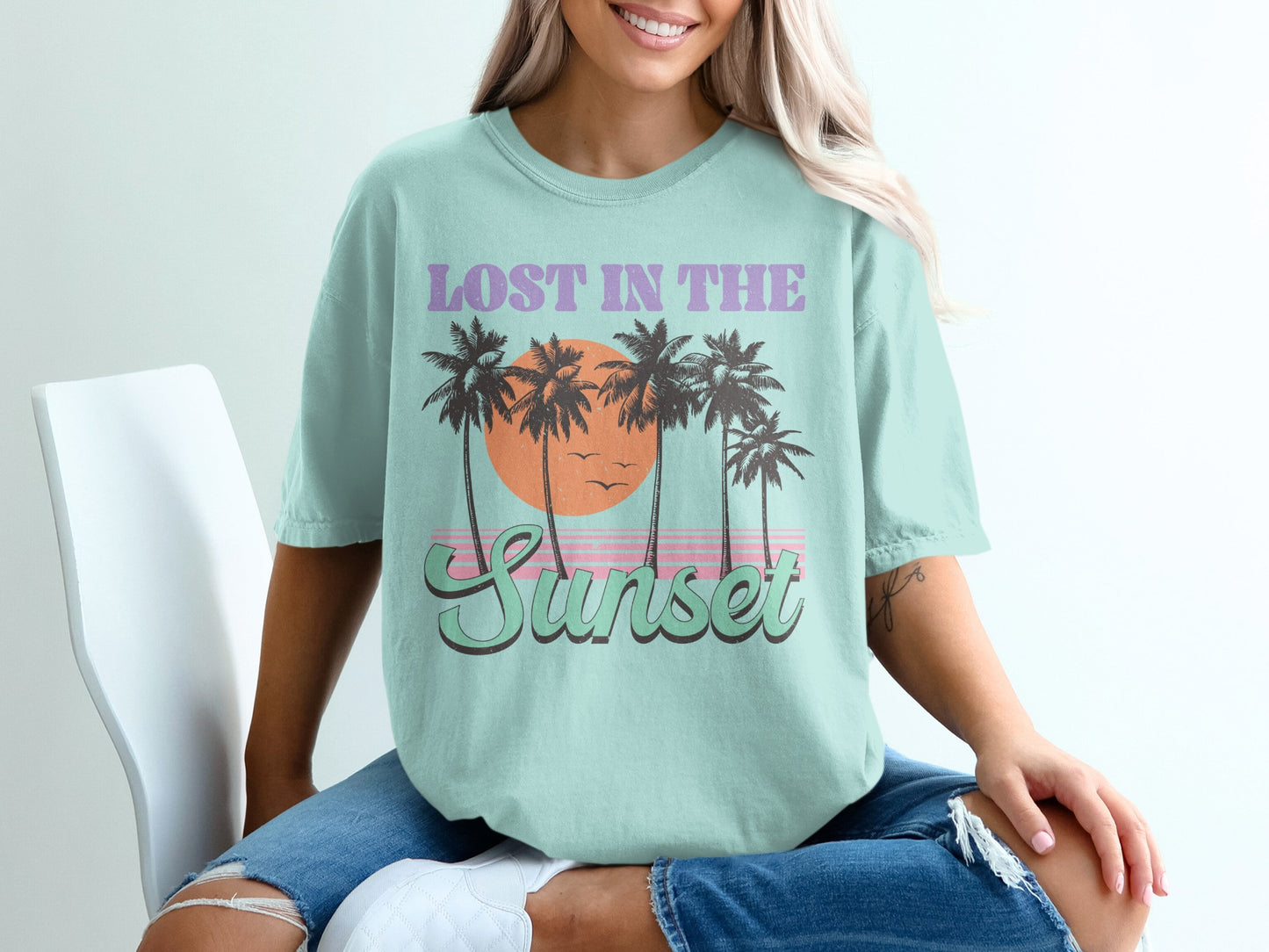 Light blue t-shirt with "Lost in the Sunset" text and palm trees.