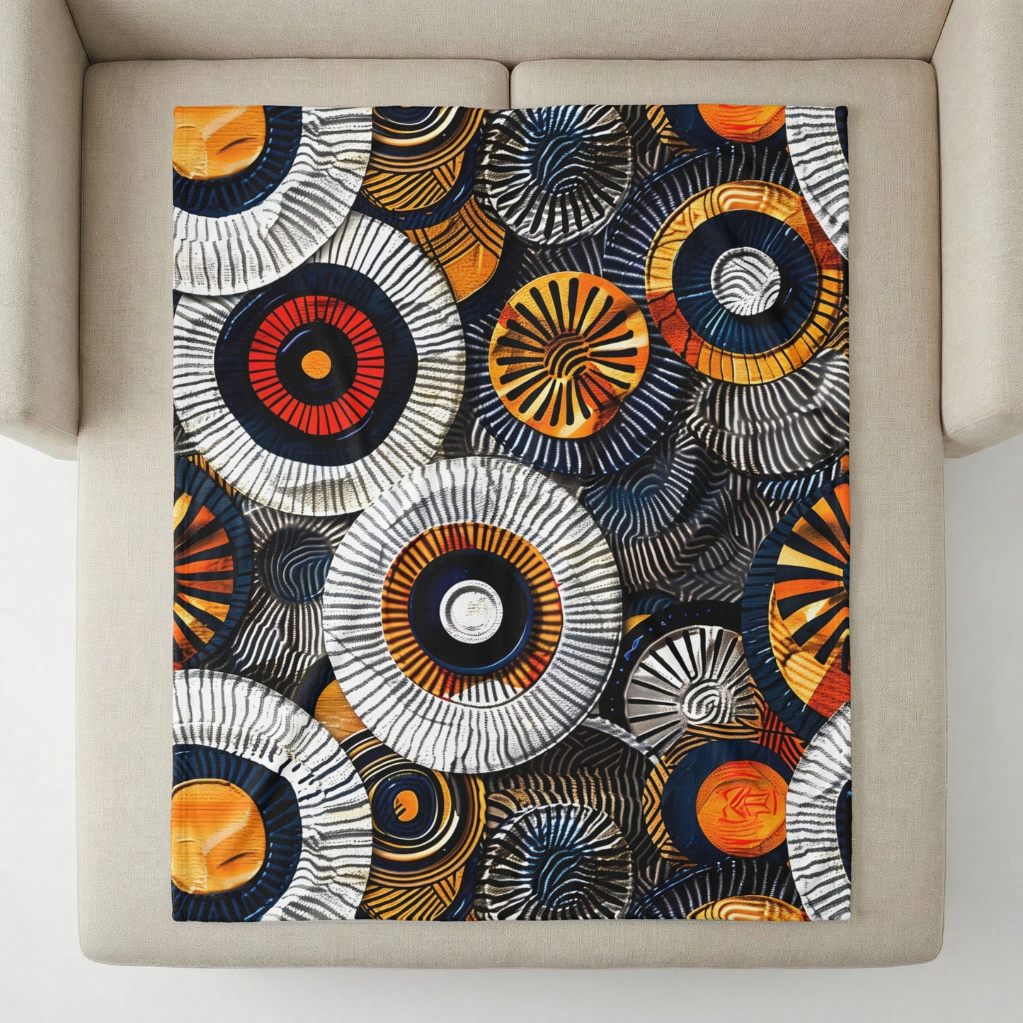 Patterned blanket with abstract circular motifs in orange, black, and white.