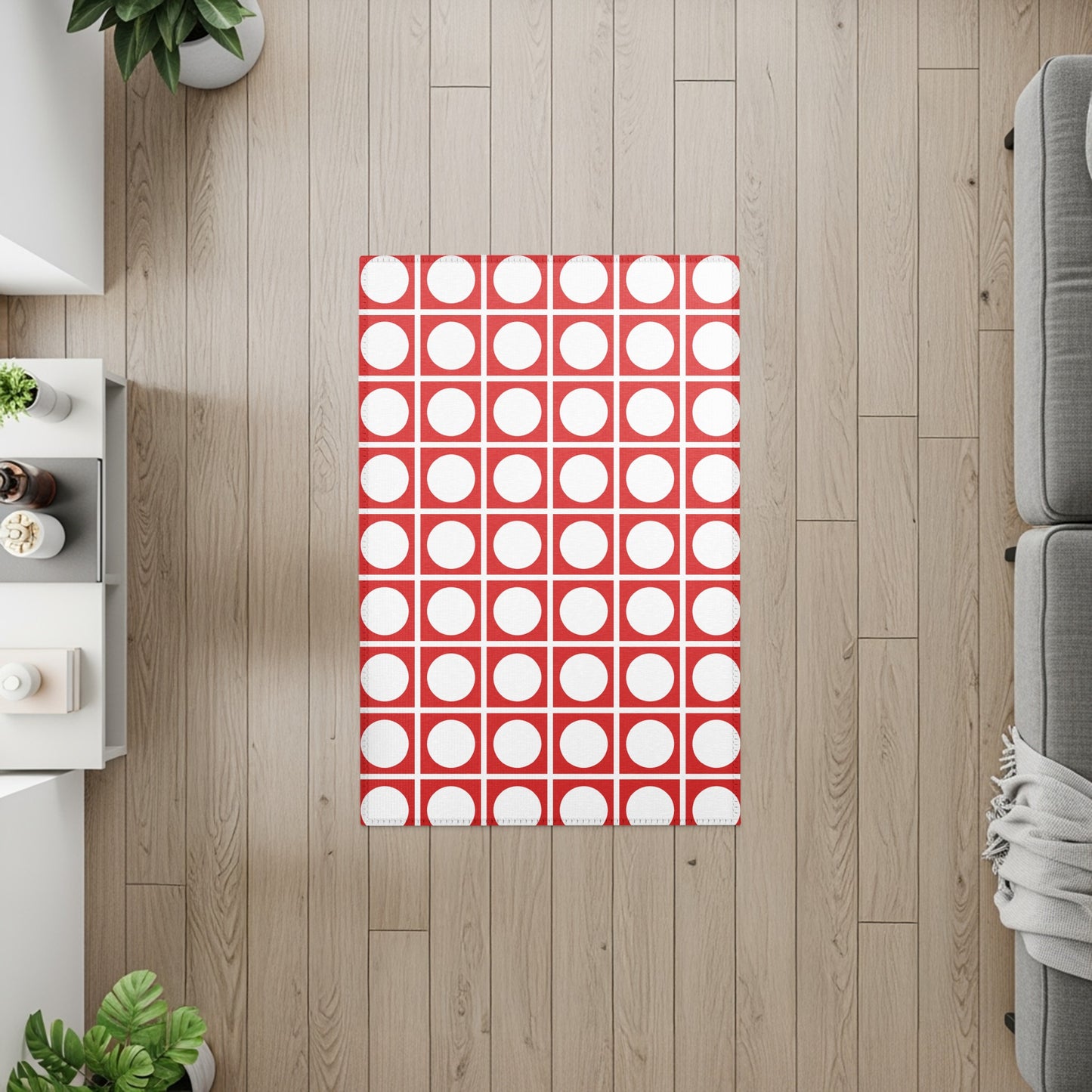 Red and white polka dot rug on a light wood floor with neutral furniture.