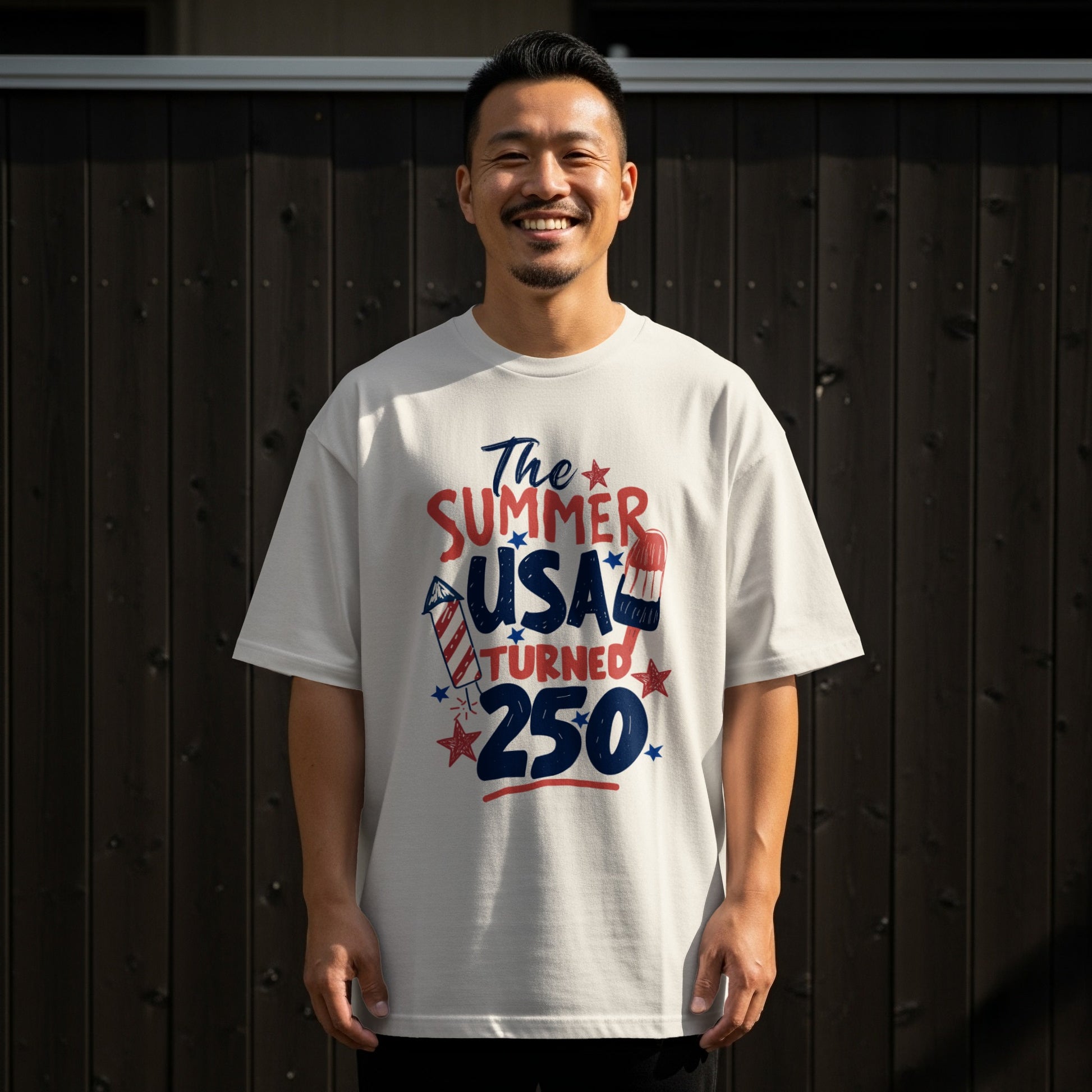 Man wearing a white t-shirt with "The summer USA turned 250" graphic.