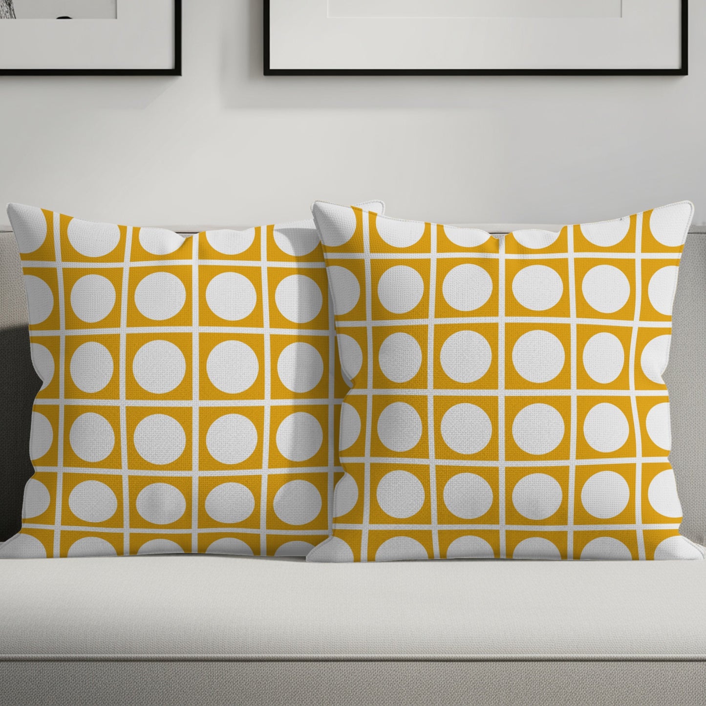 Two mustard yellow throw pillows with a white geometric circle pattern on a sofa.