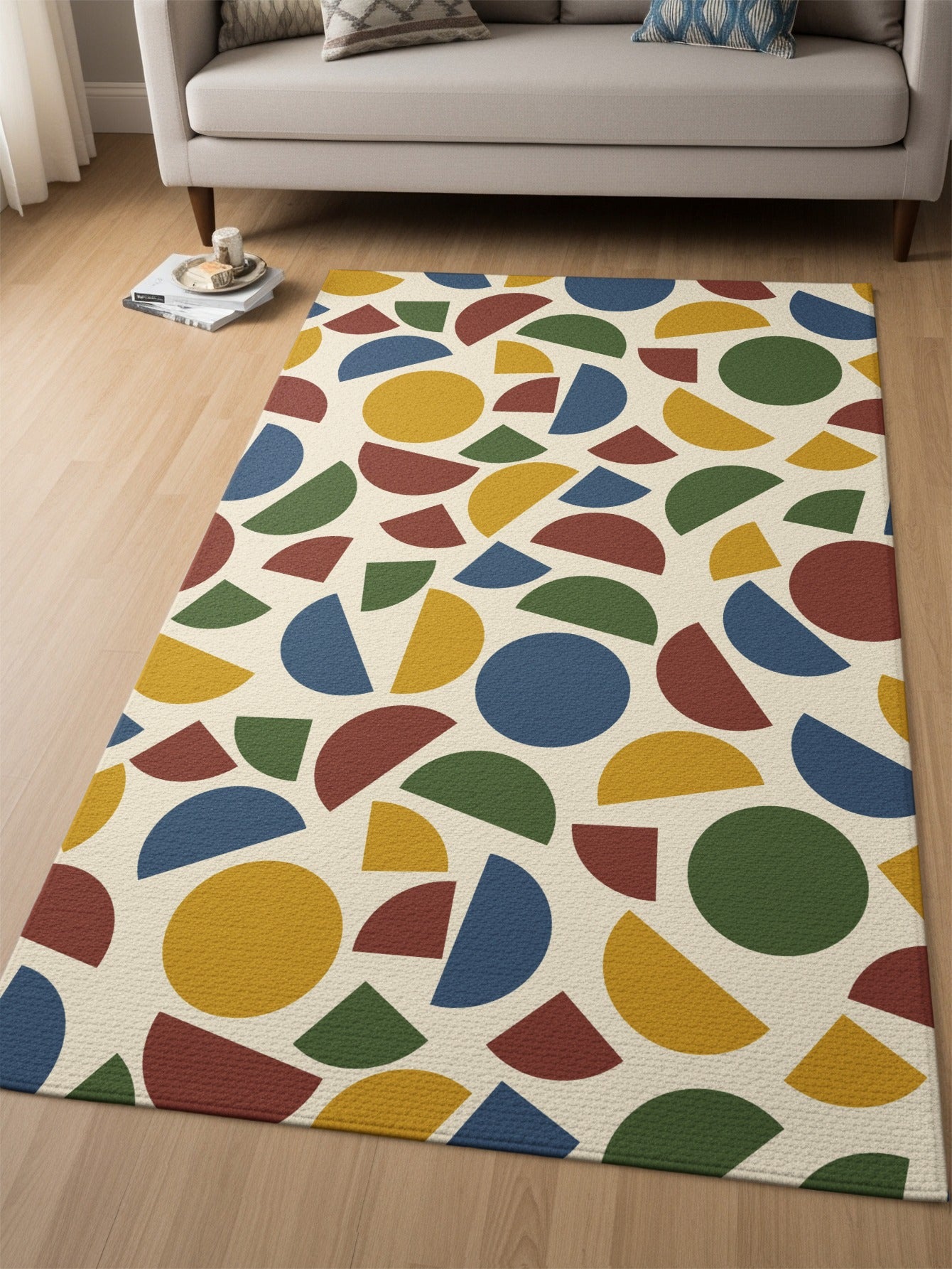 Cream rug with scattered geometric shapes in yellow, blue, green, and red.