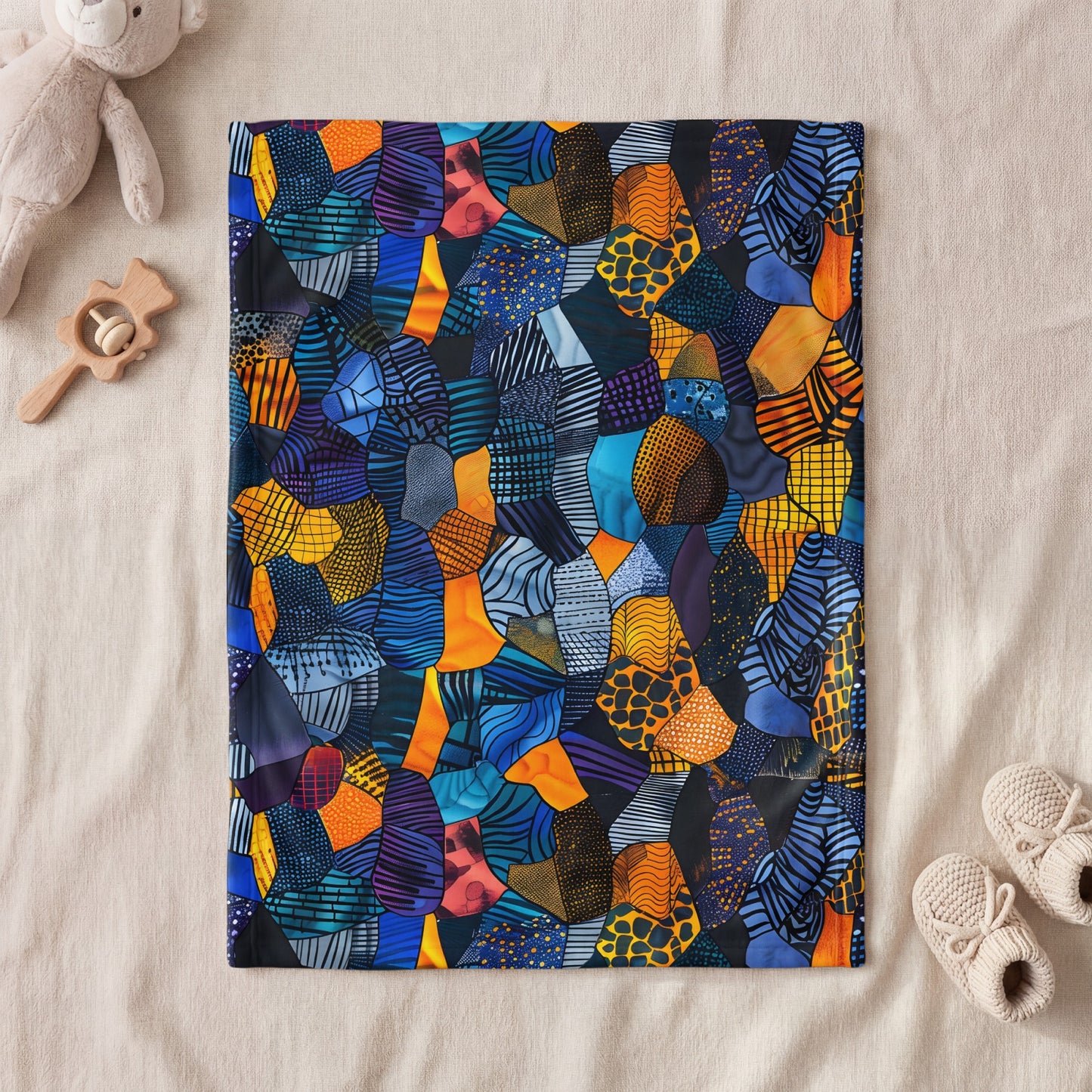 Abstract mosaic pattern blanket with blue, orange, yellow, and purple shapes.