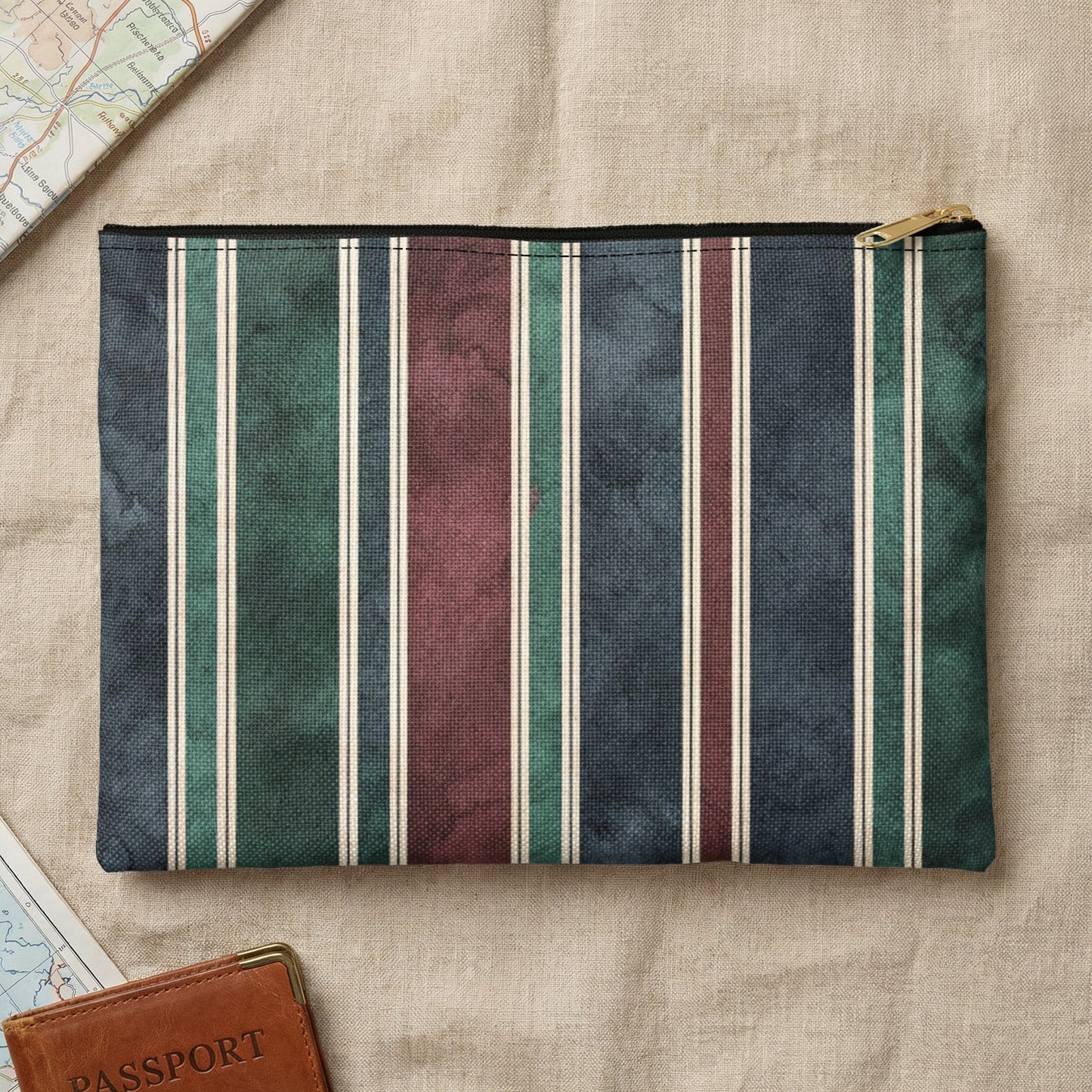 Pouch with vertical stripes in navy, green, burgundy, and cream with a gold zipper.