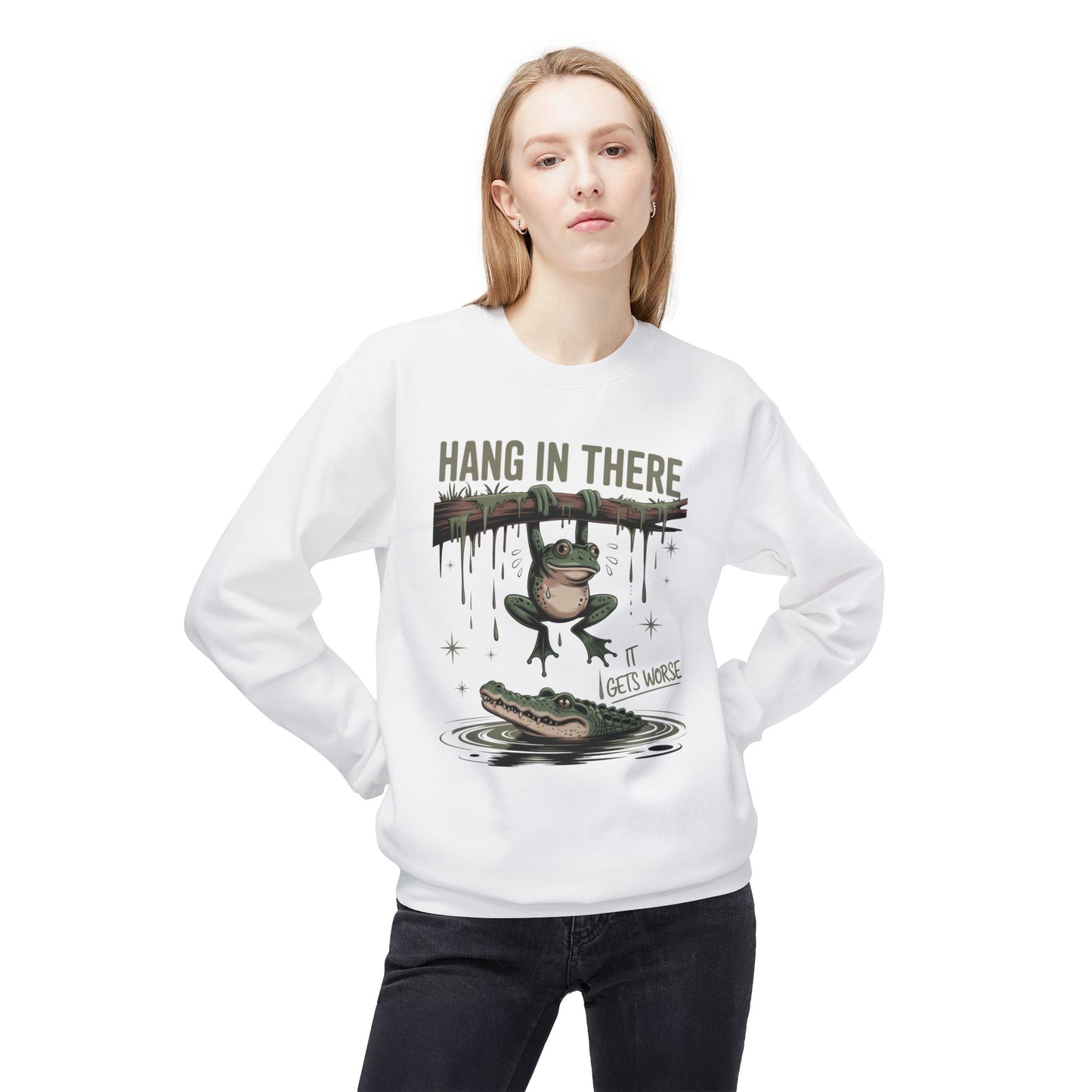 White sweatshirt with cartoon frog hanging from a branch above an alligator.