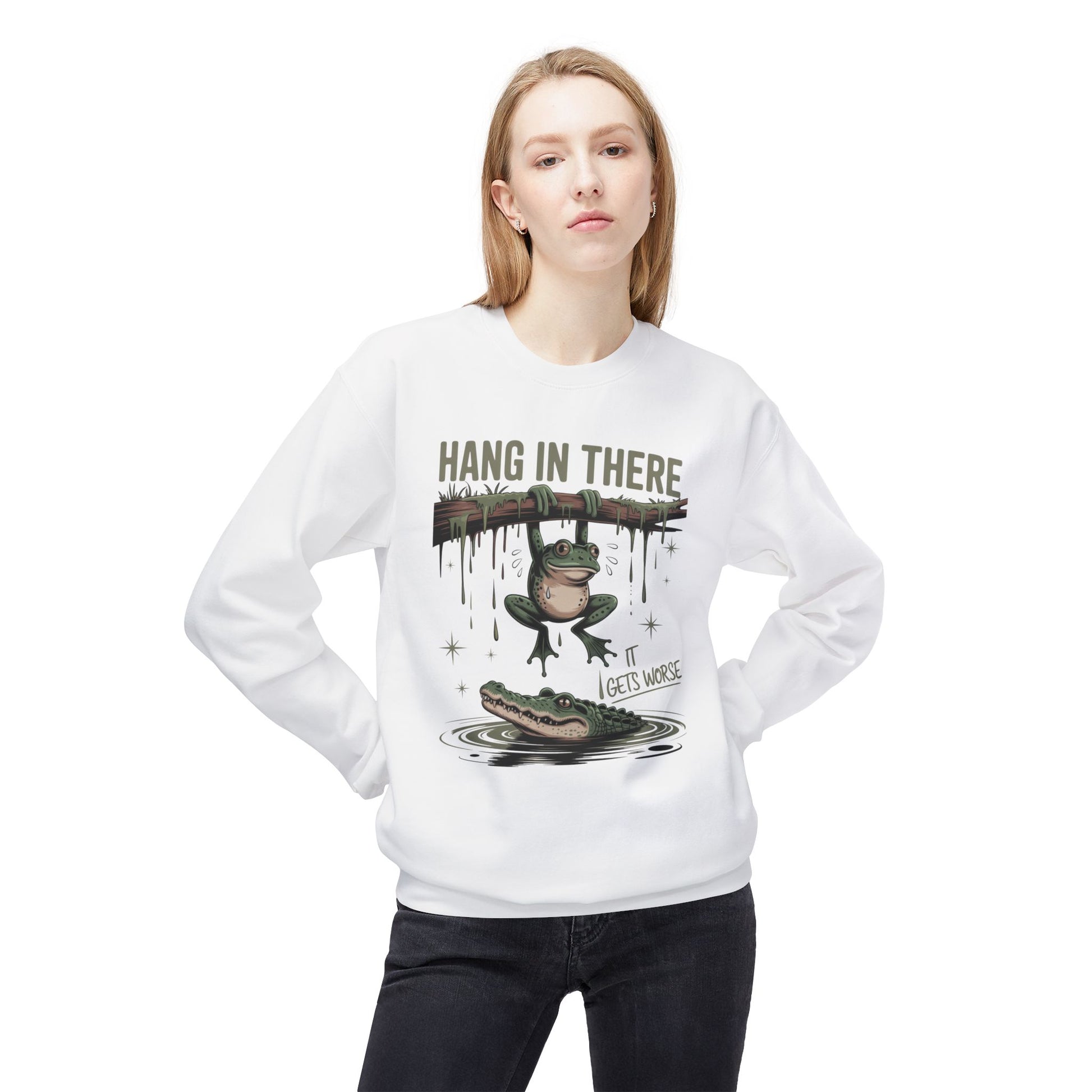White sweatshirt with cartoon frog hanging from a branch above an alligator.