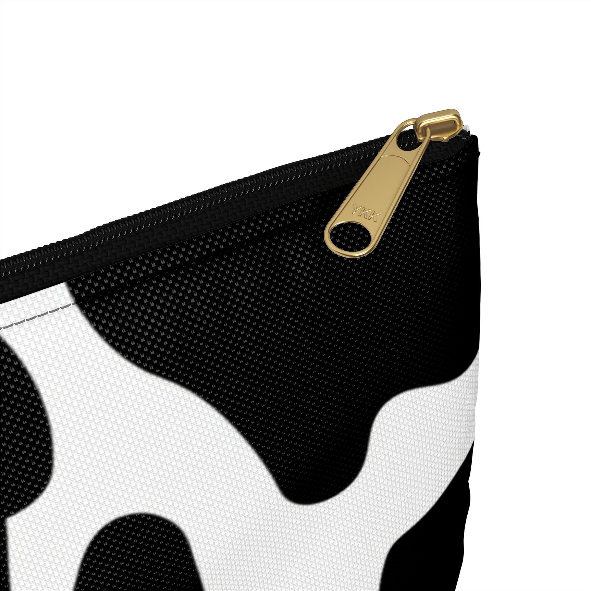Black and white cow print pouch with a gold YKK zipper detail.