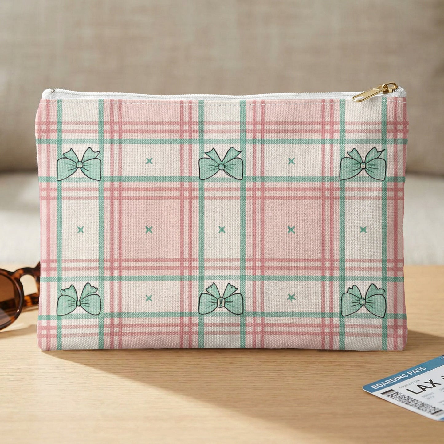 Plaid cosmetic bag with mint green bows and a small boarding pass.