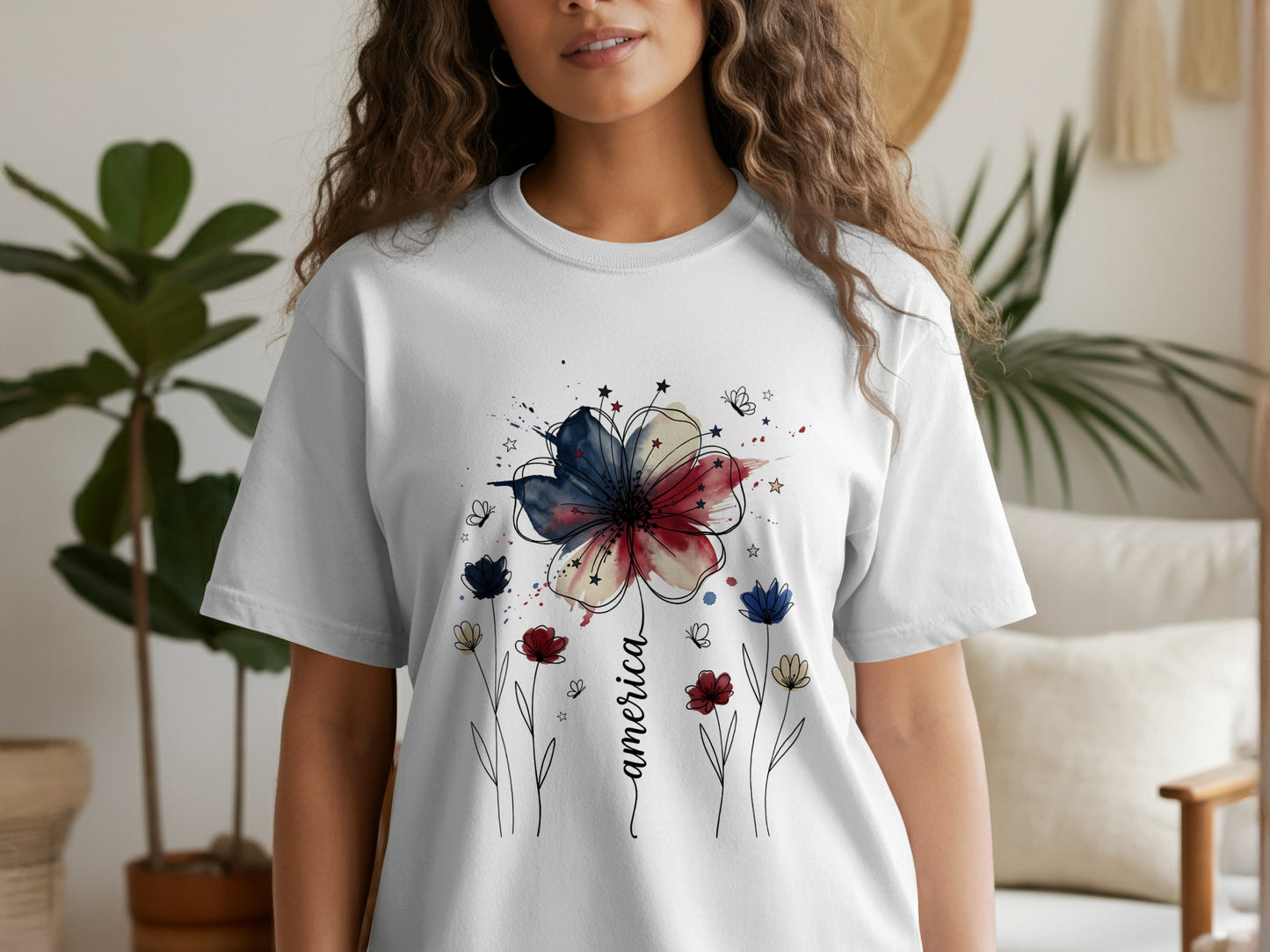 White t-shirt with a watercolor patriotic flower design and the word "America."