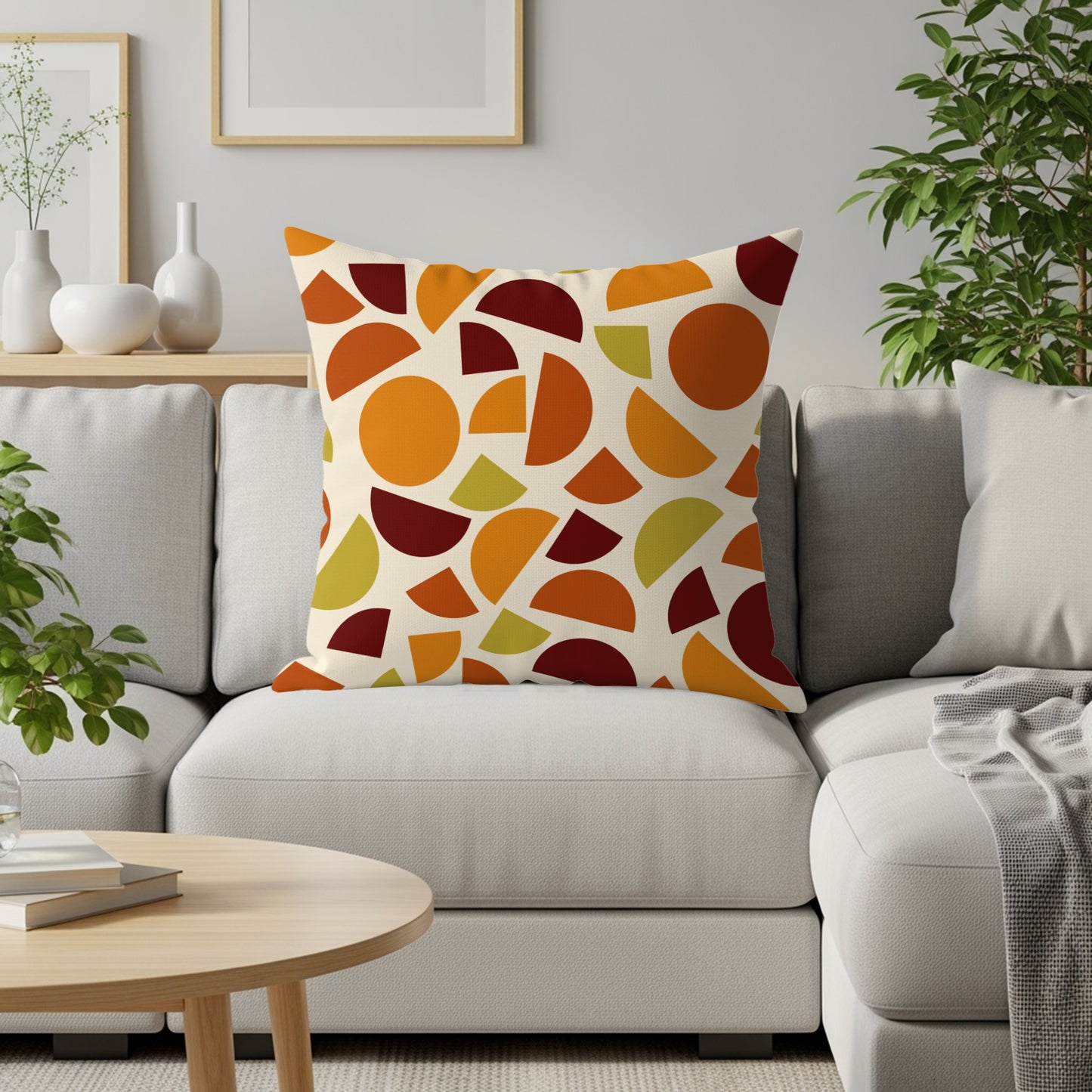 Pillow with abstract orange, maroon, and green shapes on a cream background.