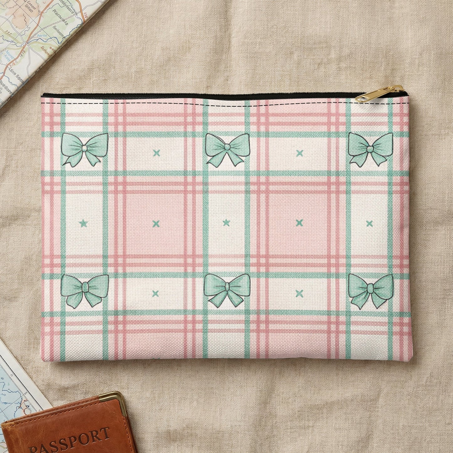Clutch with pink and green plaid, featuring repeated bow pattern and a golden zipper.