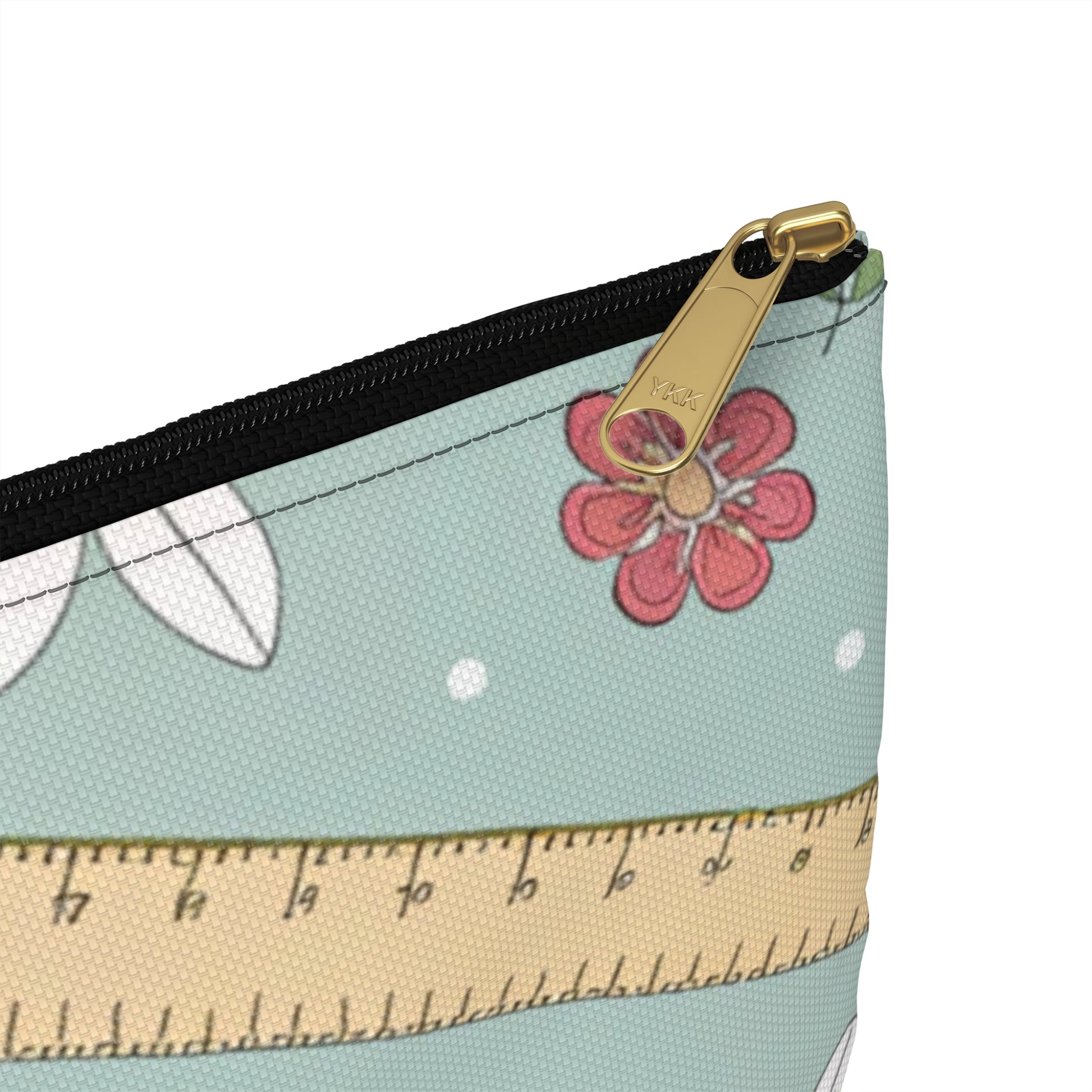 Cosmetic bag with a YKK zipper, ruler pattern, flowers, and leaves.