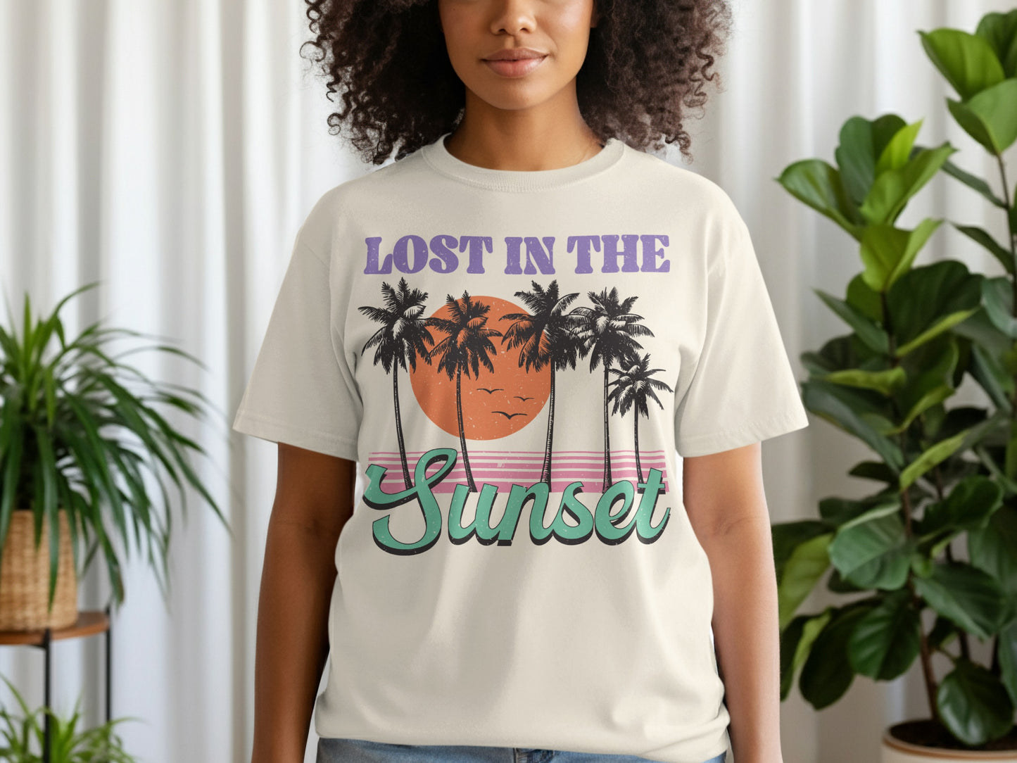 T-shirt with palm trees and text "LOST IN THE Sunset" against a sunset.
