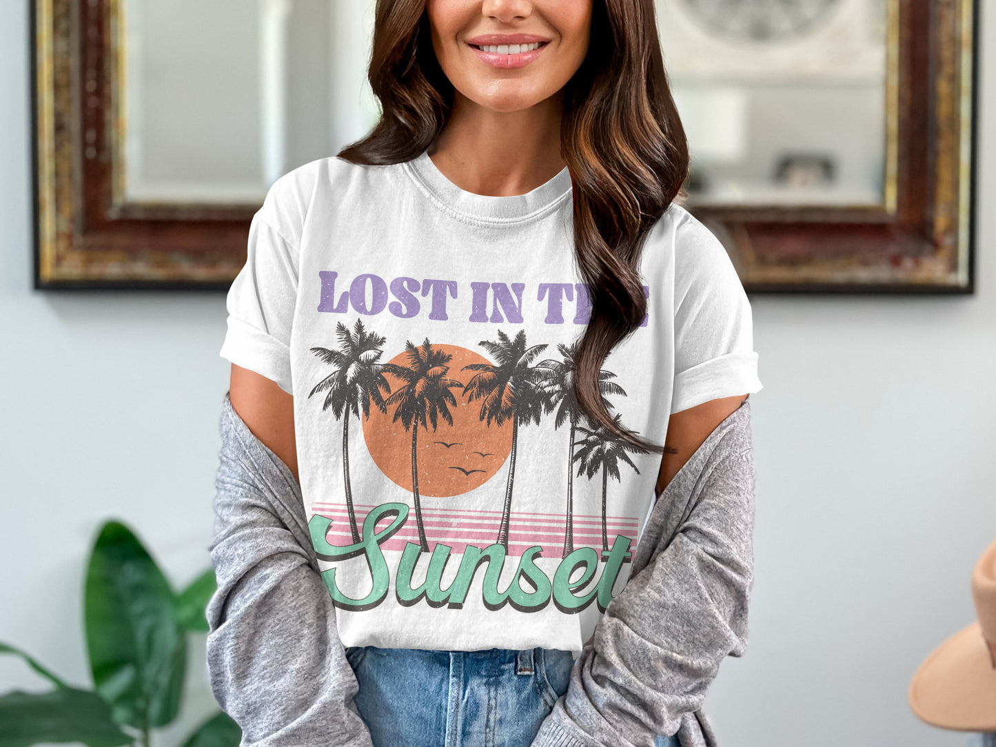White t-shirt with "LOST IN THE SUNSET" and palm trees graphic.