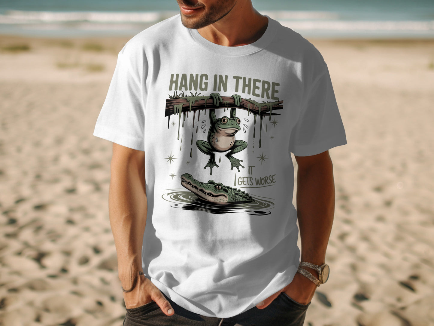 White t-shirt with a frog hanging from a branch over an alligator.
