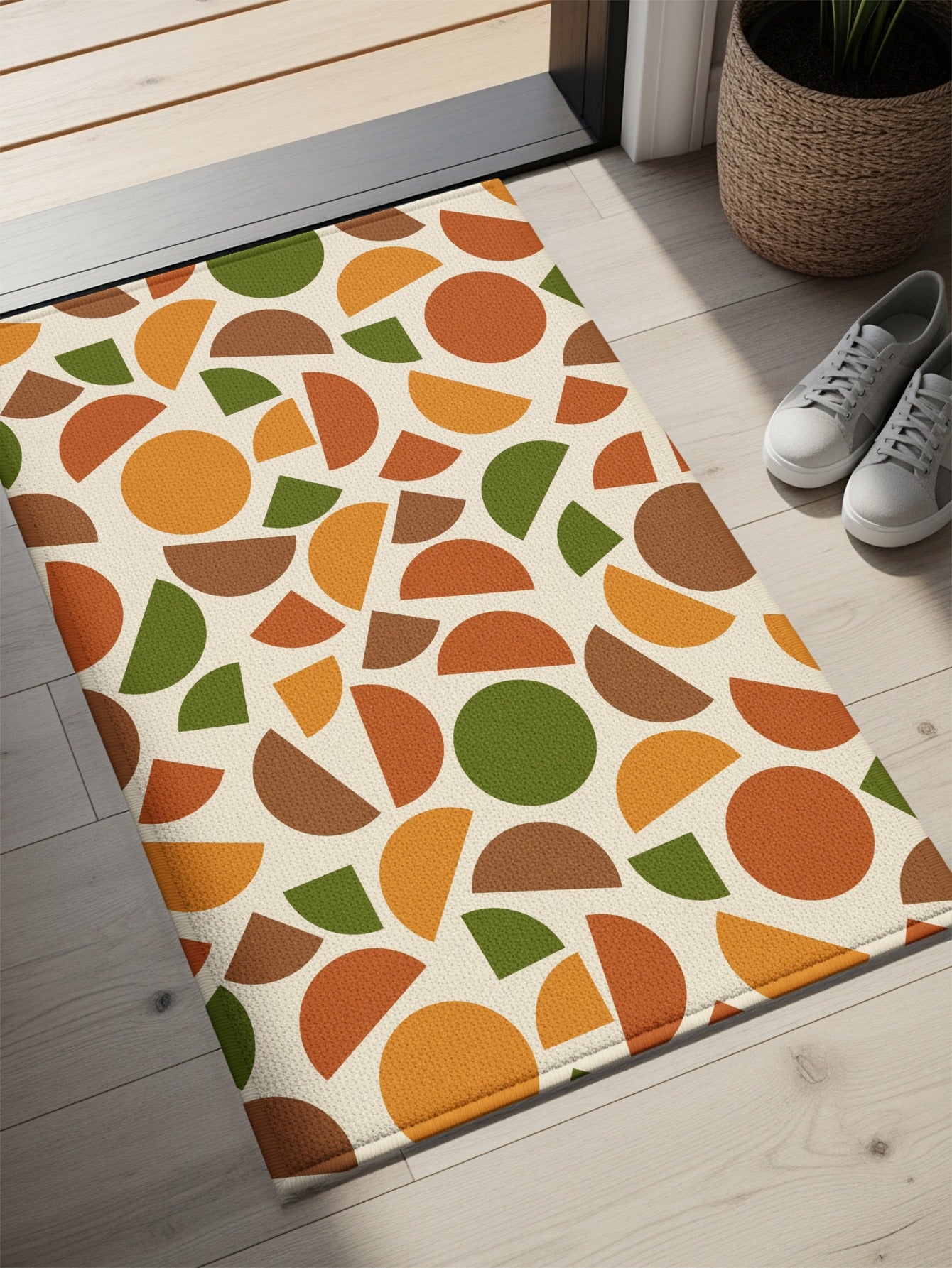 Area rug with cream background and abstract geometric pattern in orange, brown, and green.