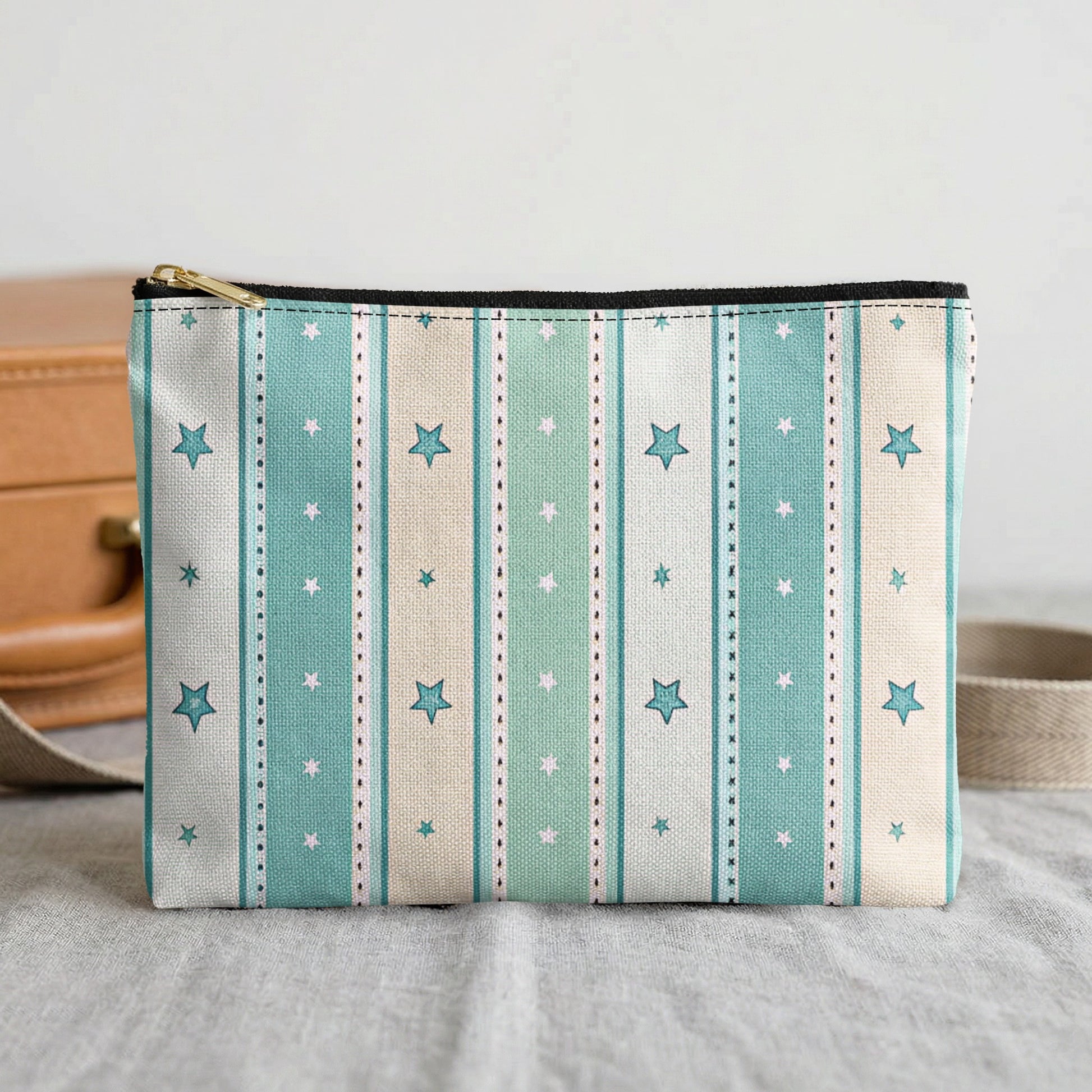 Cosmetic bag with blue, green, and beige stripes with white and blue stars.