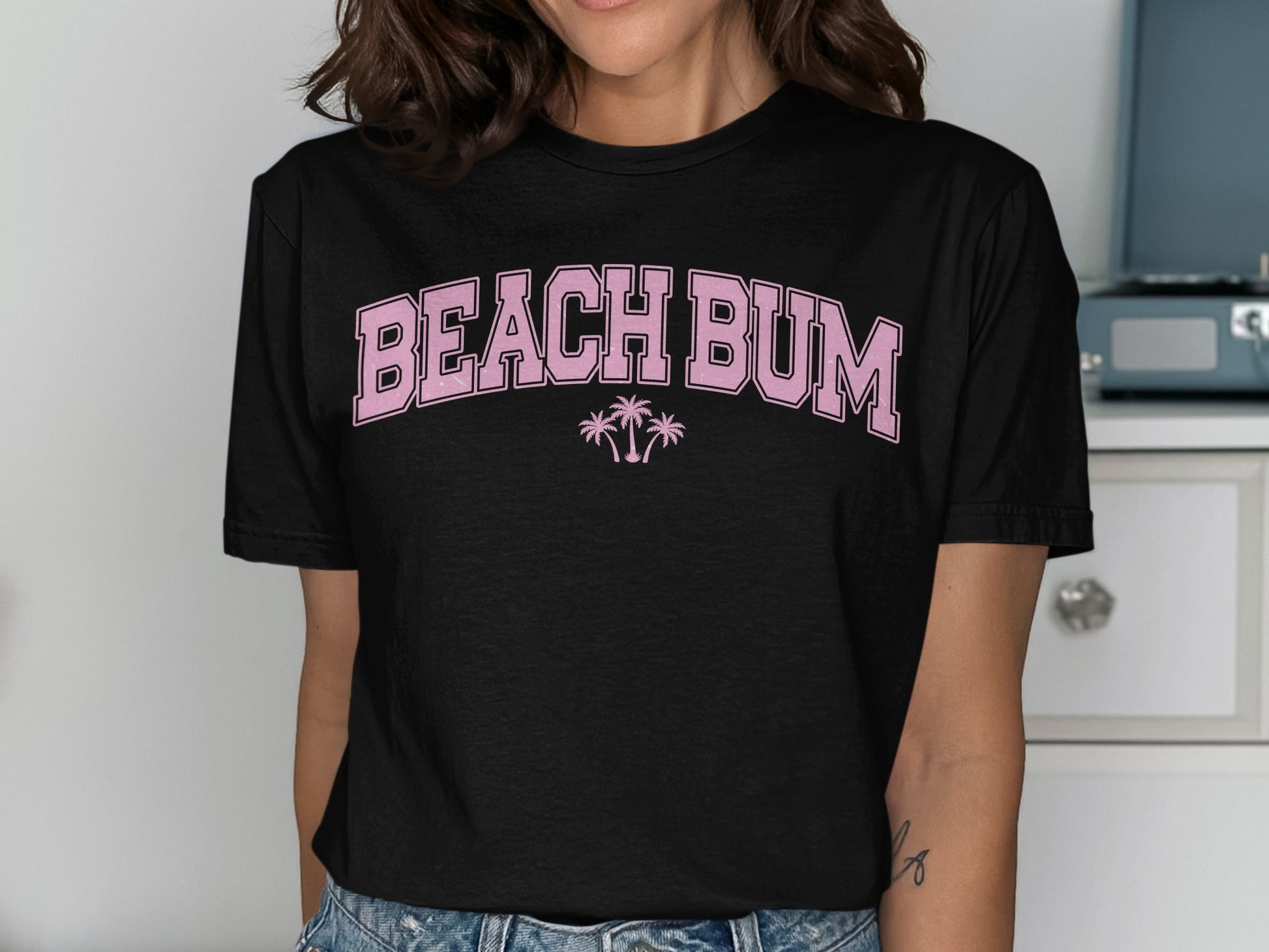 Black t-shirt with "BEACH BUM" and palm trees in pink lettering.