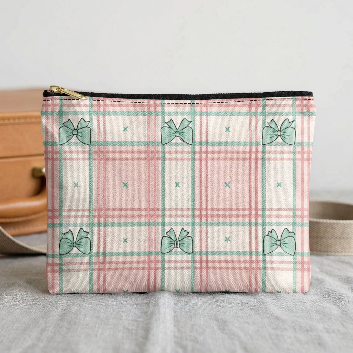 Cosmetic bag with pink and green plaid and a consistent bow pattern.