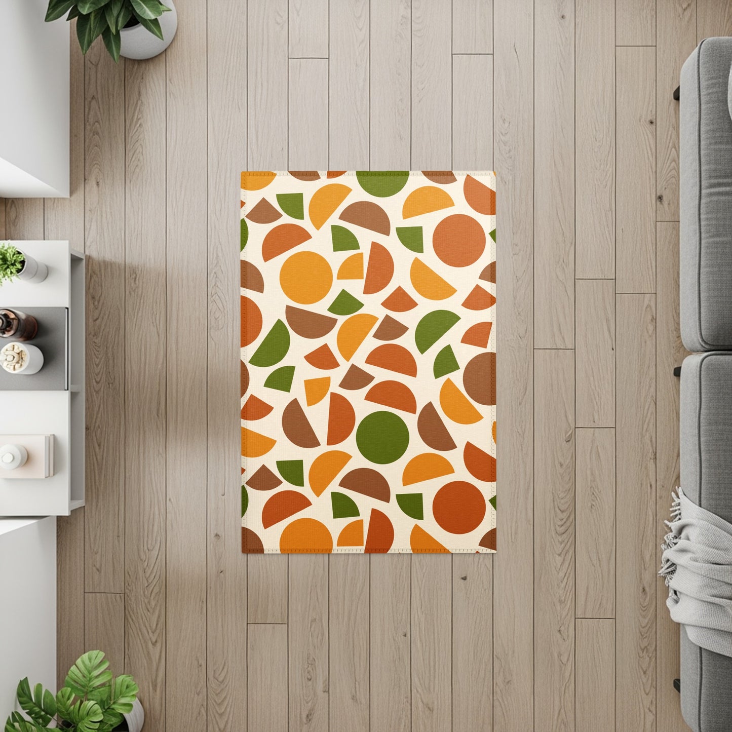 Rectangular rug with an abstract pattern of circles and semicircles in orange, brown, and green.