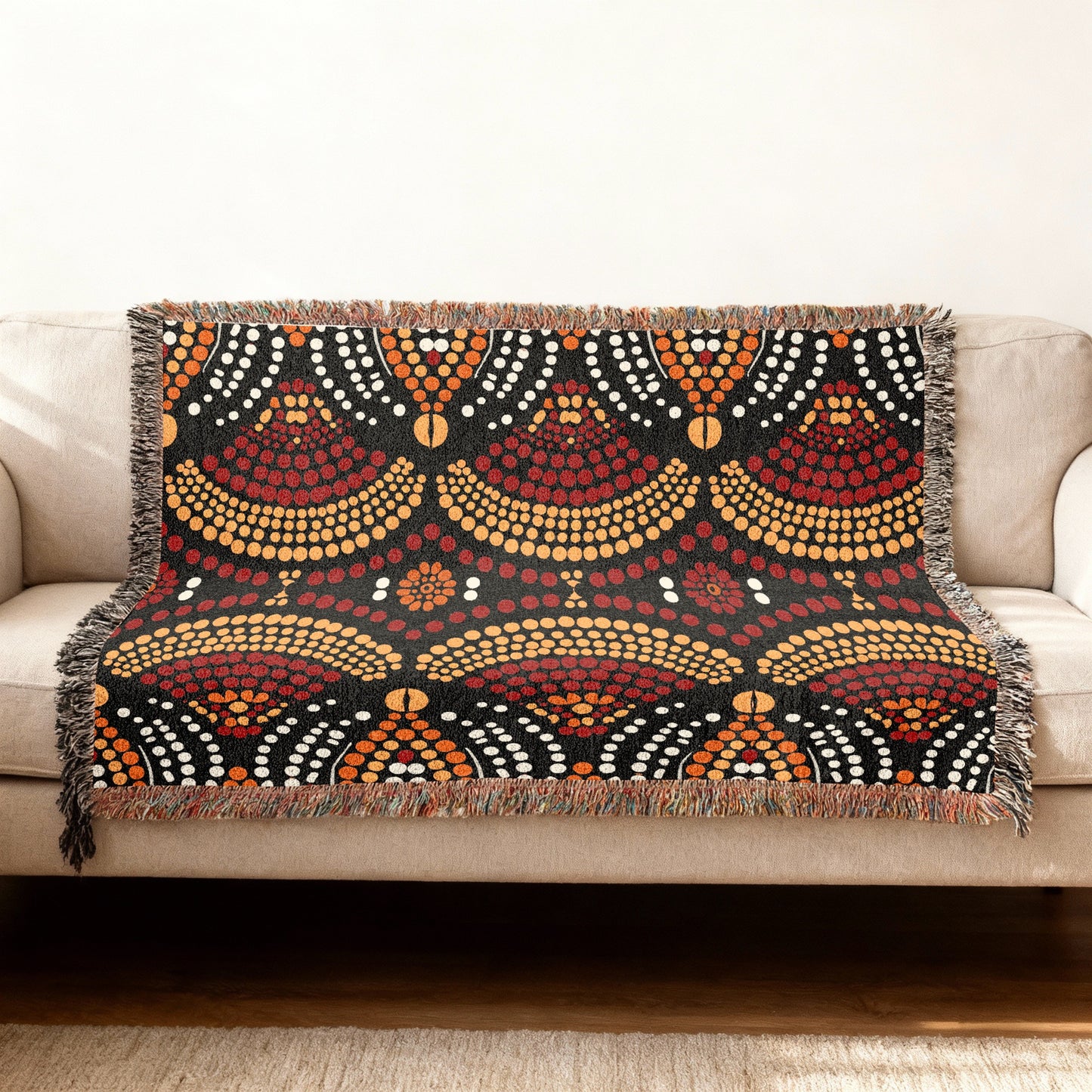Throw blanket with black background and red, orange, and white dot pattern.