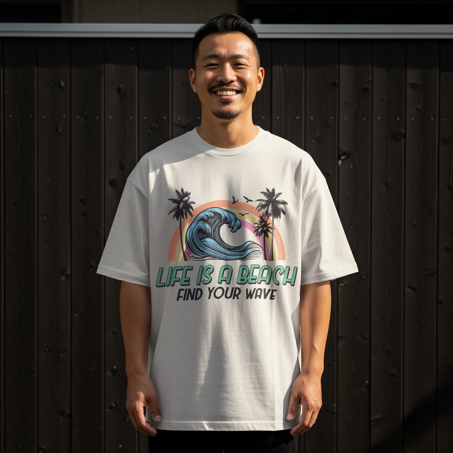 T-shirt with a graphic of a rainbow wave, palm trees, and text "Life is a beach find your wave."