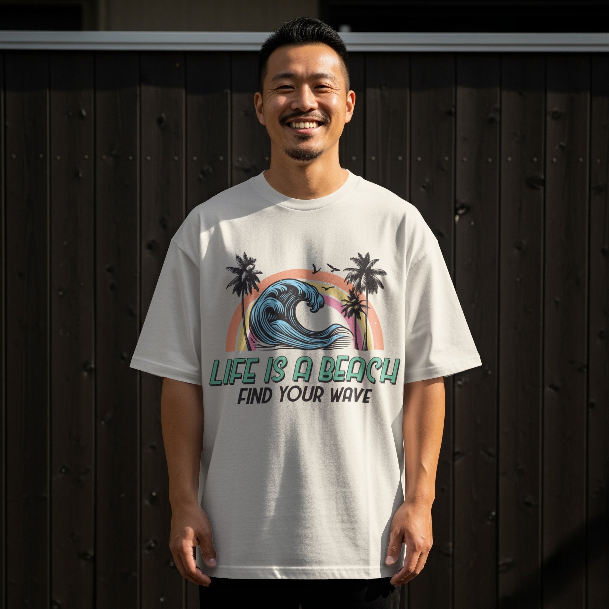 T-shirt with a graphic of a rainbow wave, palm trees, and text "Life is a beach find your wave."