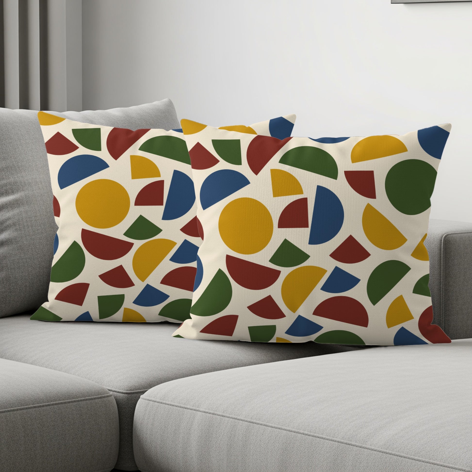Two decorative pillows with a cream background and colorful geometric patterns.