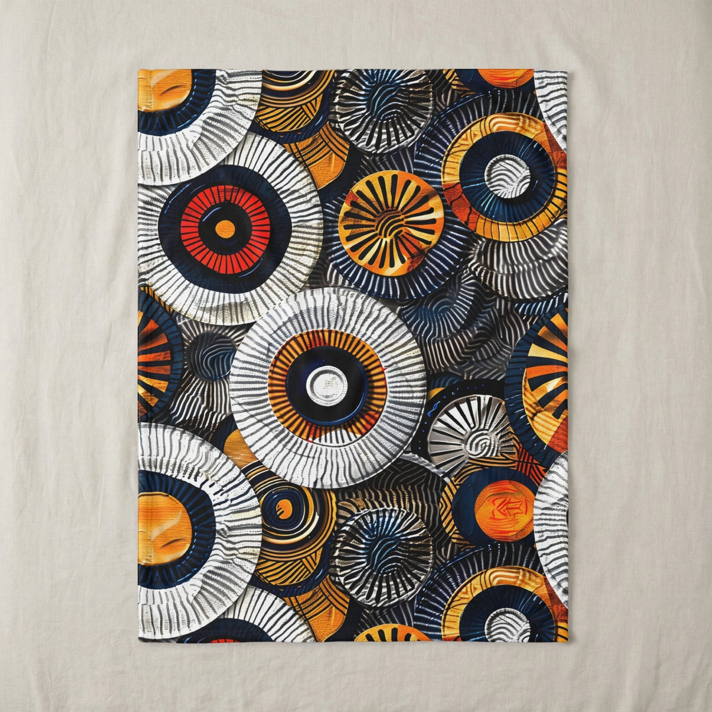 Textile with abstract circular patterns in orange, yellow, blue, black, and white.