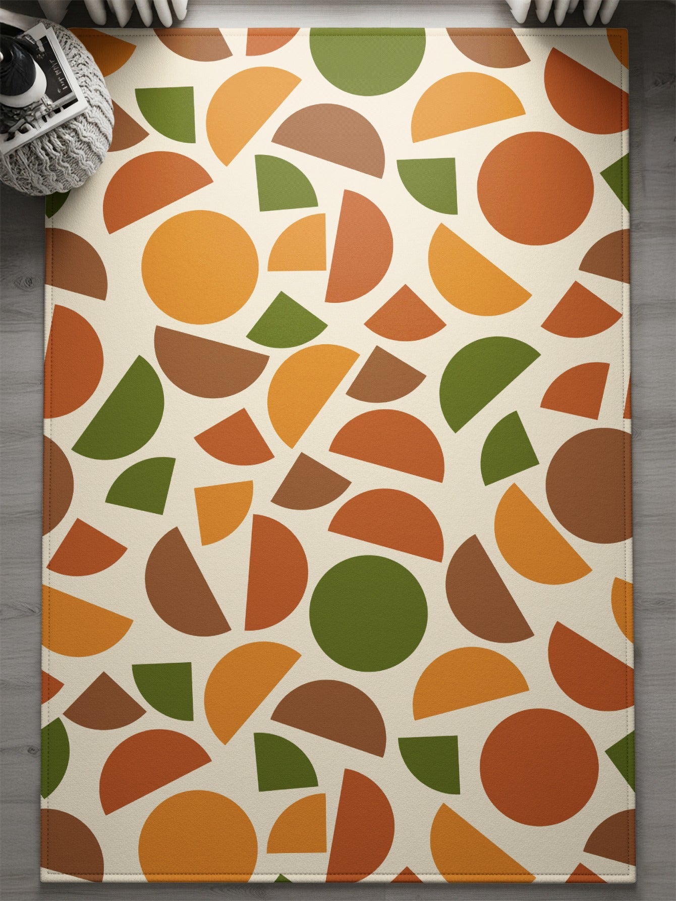 Cream rug with scattered semicircles and circles in orange, brown, and green.