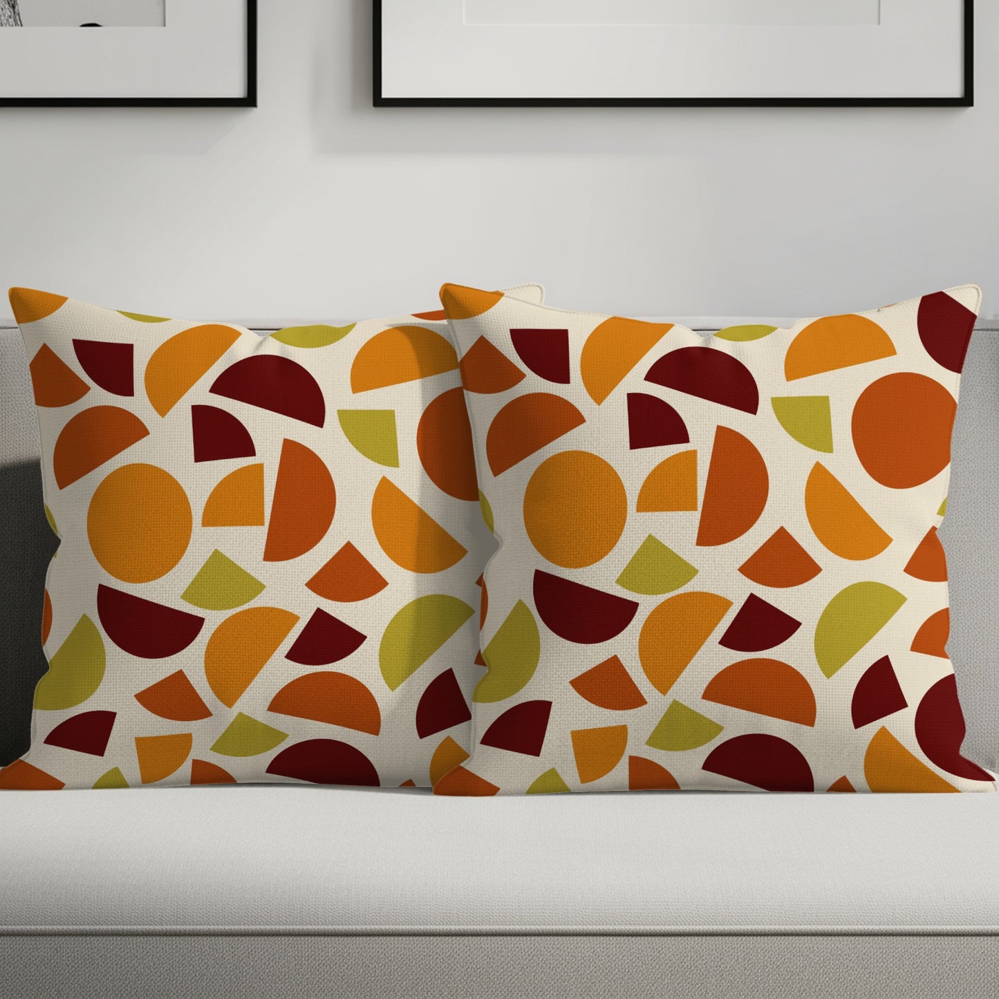 Two throw pillows on a couch with a modern geometric pattern of circles and semi-circles.