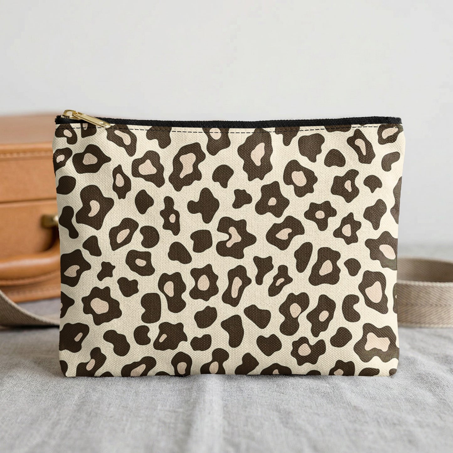 Pouch with beige and brown leopard print pattern and gold zipper.