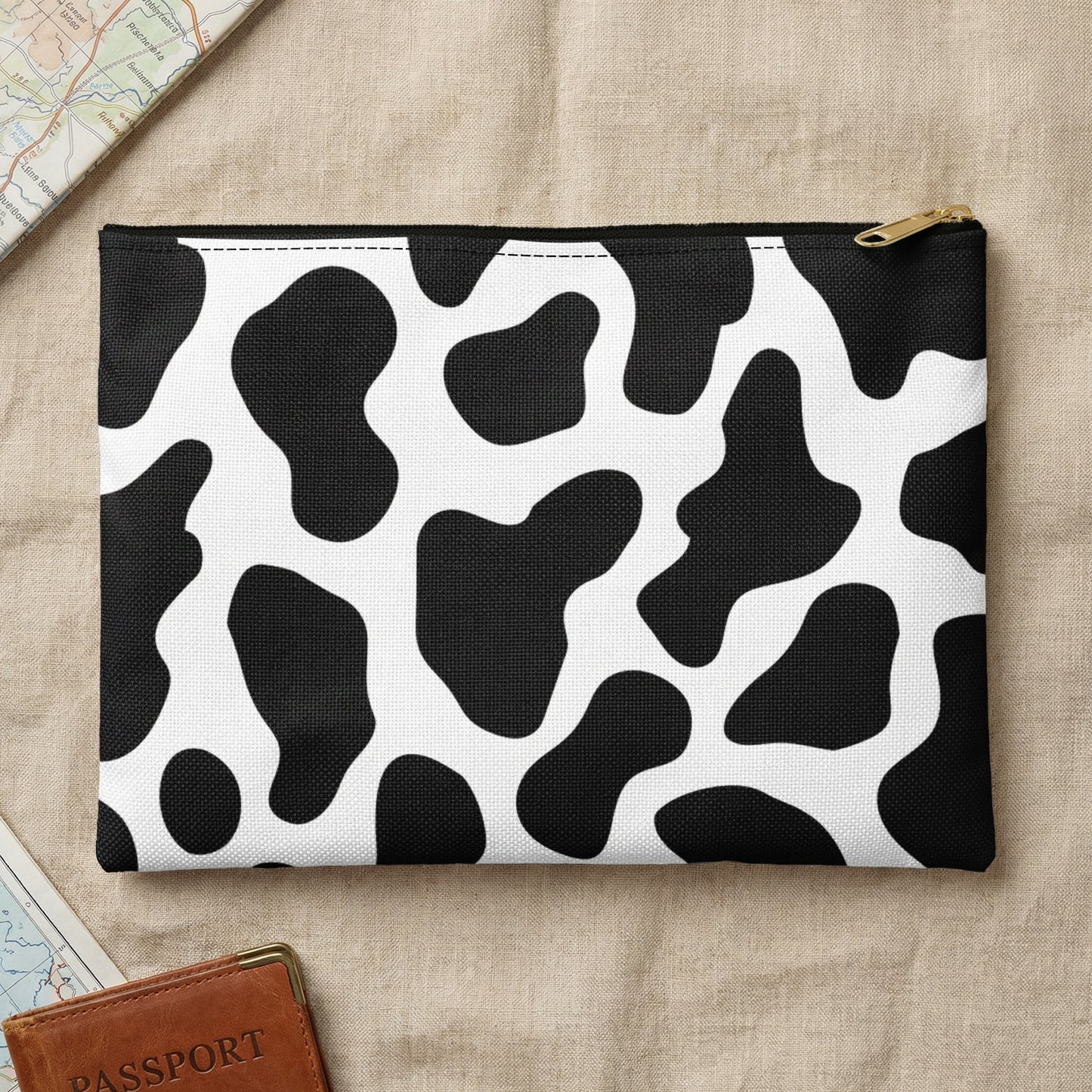 Zippered pouch with black and white cow print pattern.